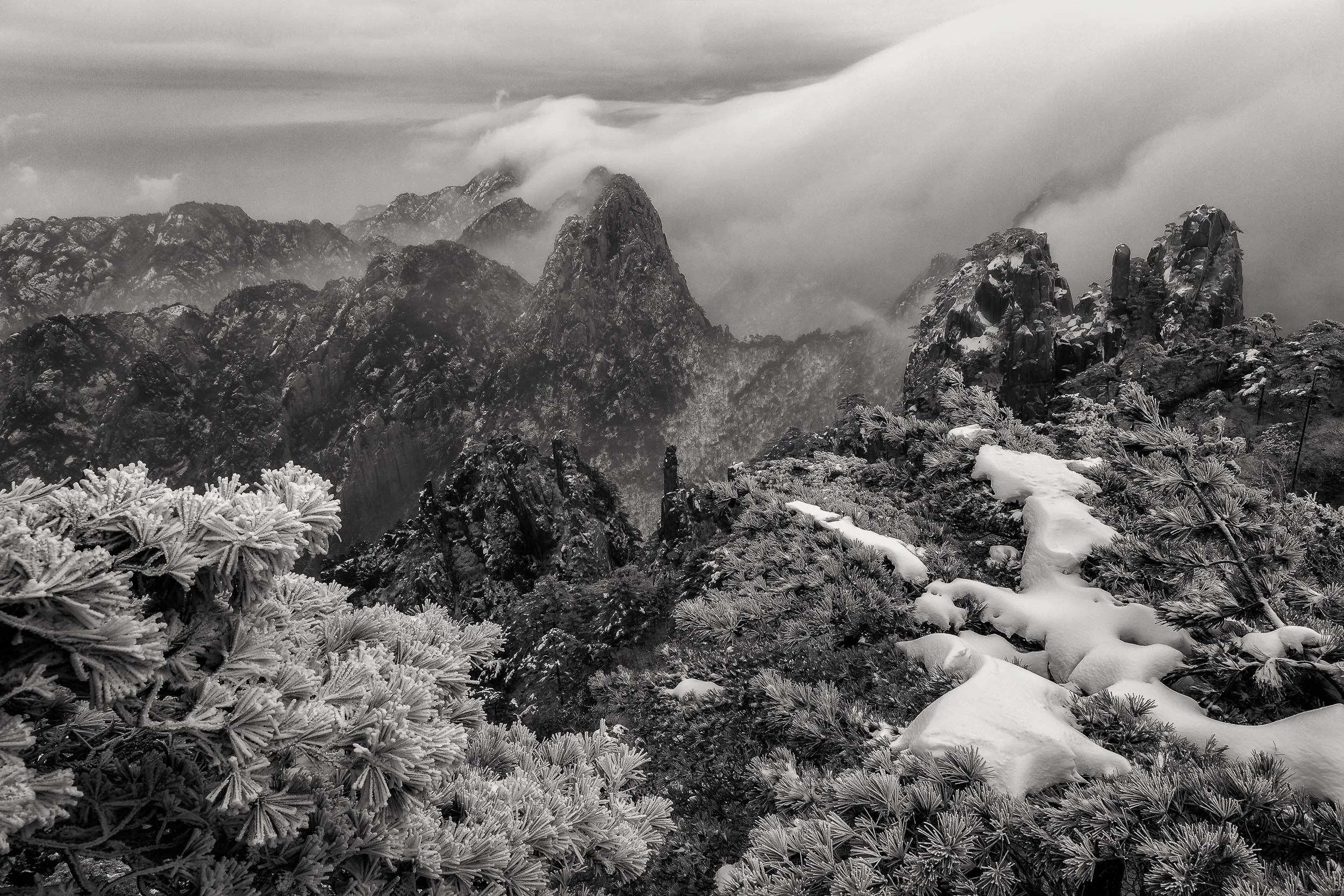 Clearing mist reveals a spectacular landscape on Huangshan (i.e., Yellow Mountain) in China .
