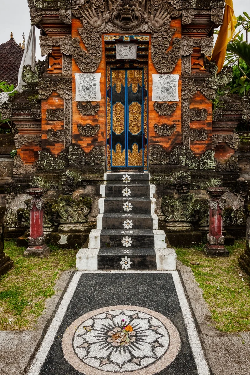 An ornately decorated pathway leads to a beautiful entrance to a Hindu Shrine in Bali, Indonesia .