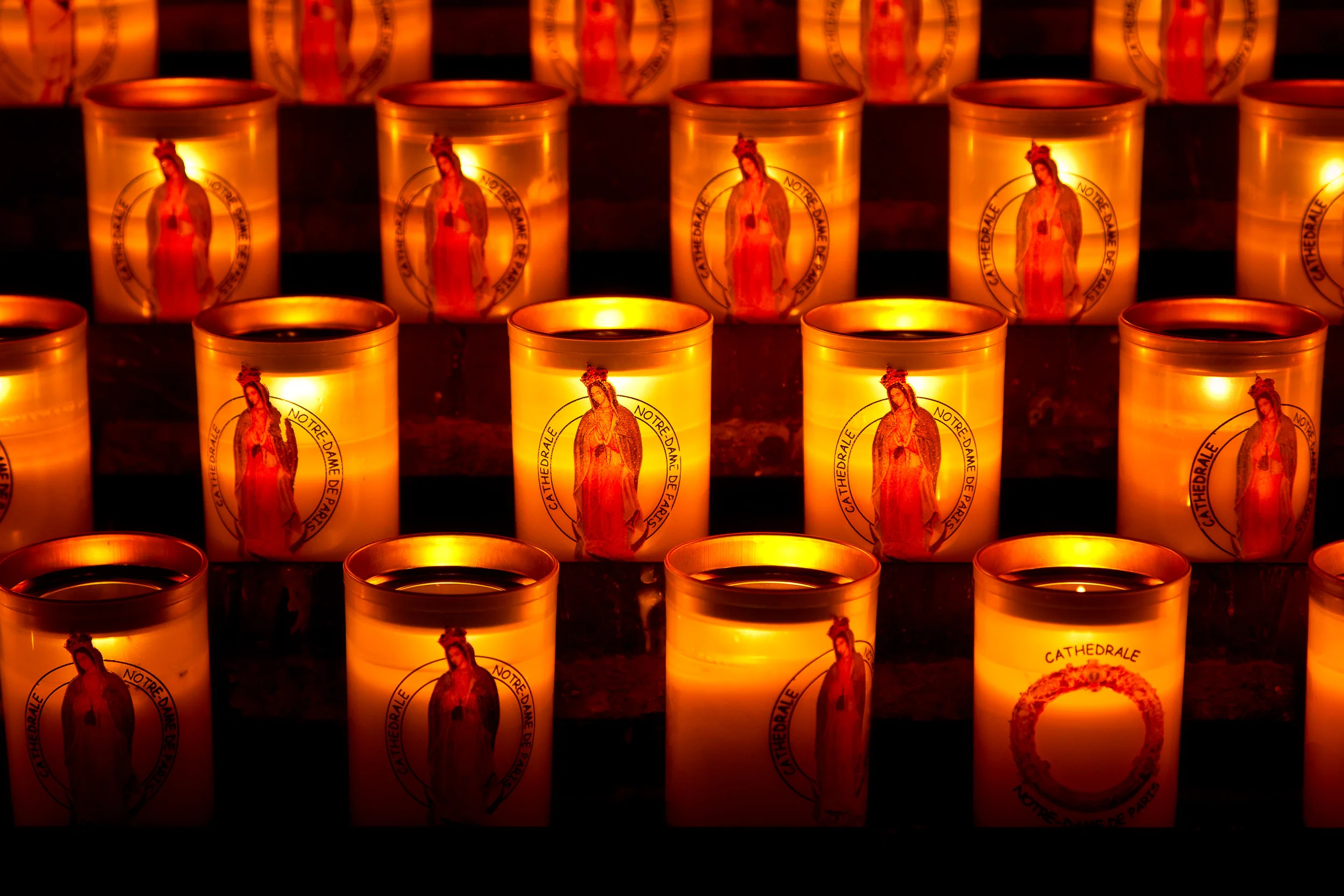 A close up view of candles , featuring the Virgin Mary , inside the Notre Dame Cathedral in Paris, France