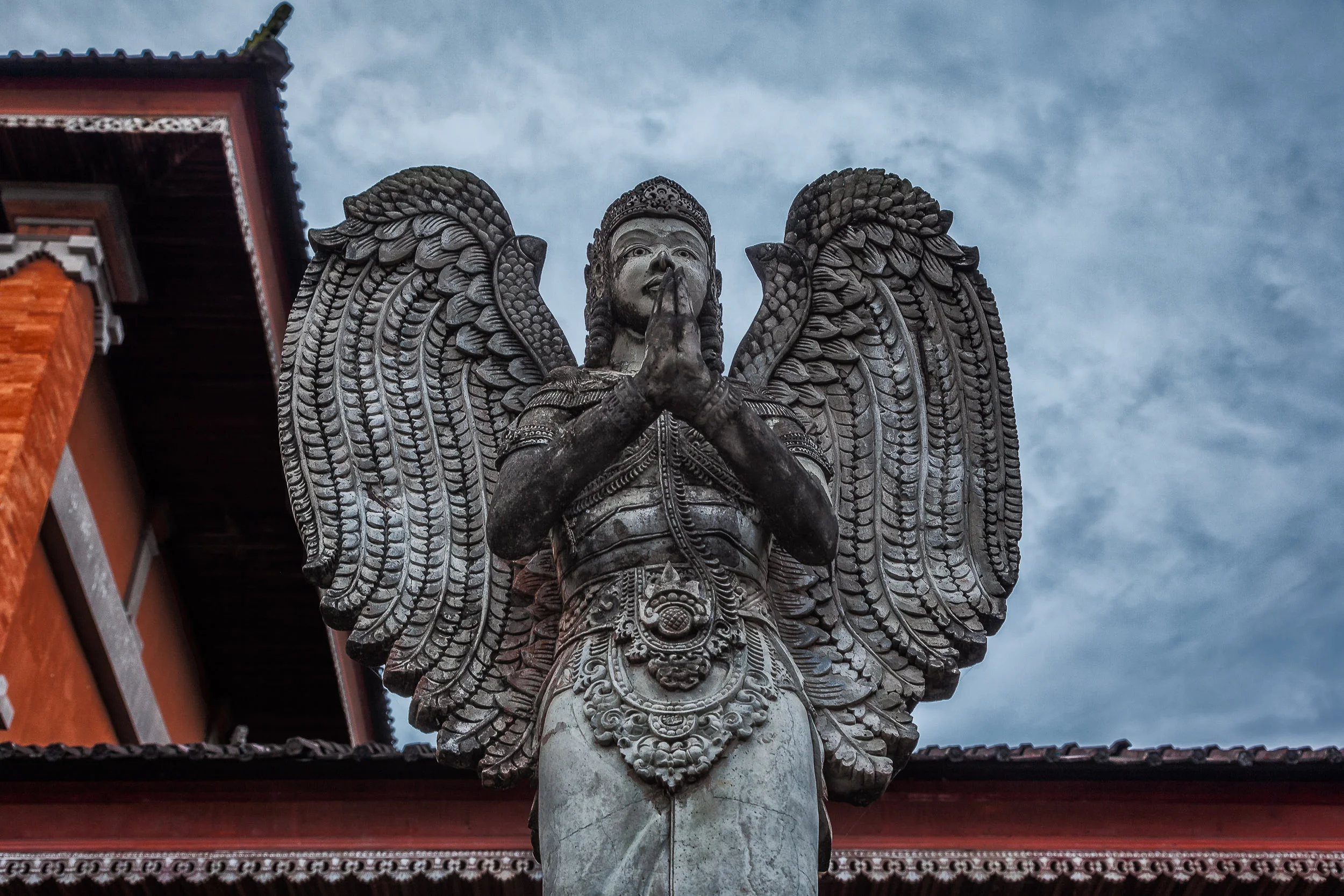 An imposing staute pictured against a stormy sky in Bali, Indonesia .