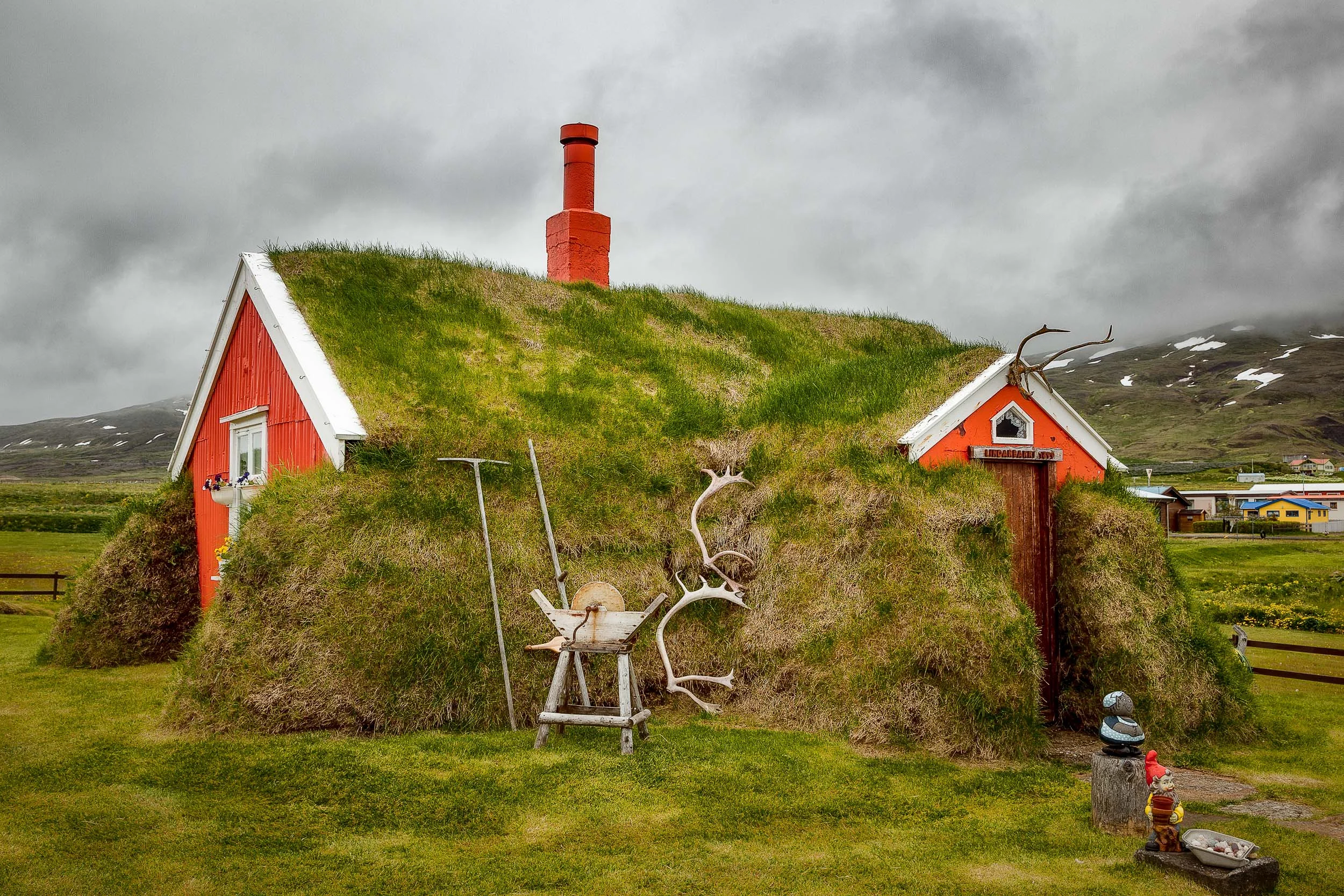 A colorful view of the famous Lindarbakki turf house in the village of Bakkagerdi in Iceland .