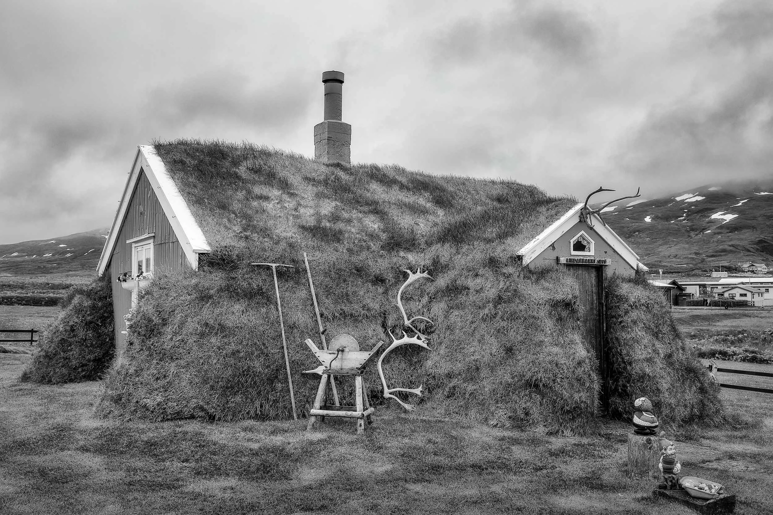 A black and white rendering of the famous Lindarbakki turf house in the village of Bakkagerdi in Iceland .