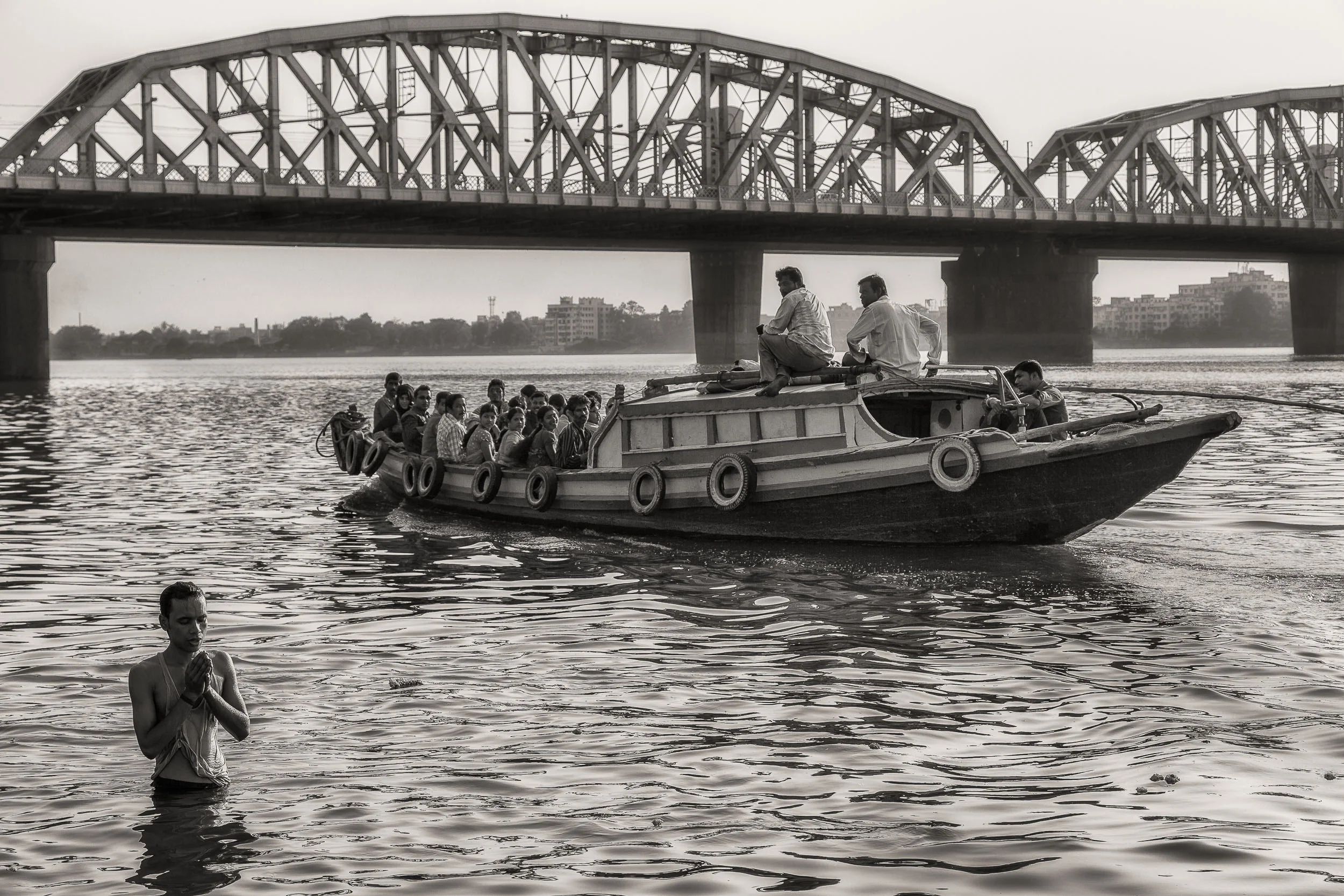 Devotee near the Howarth Bridge on the Hooghly River in Kolkata, India.