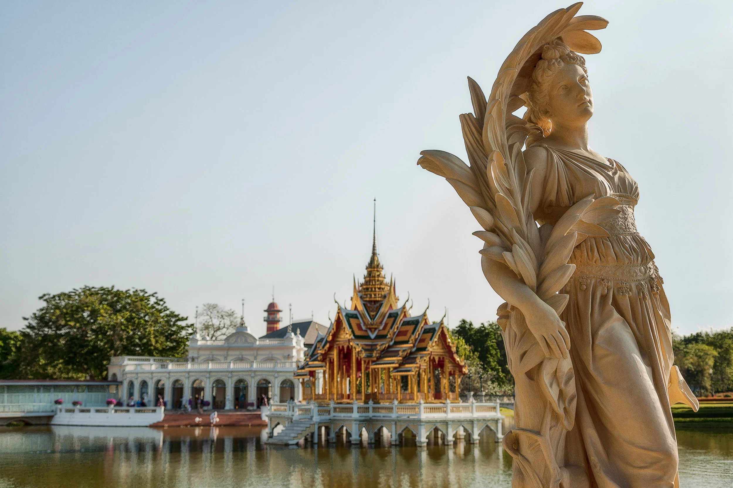 A graceful European statue in front of a classic T hai-style pavillion at Bang Pa In near Ayutthaya, Thailand .