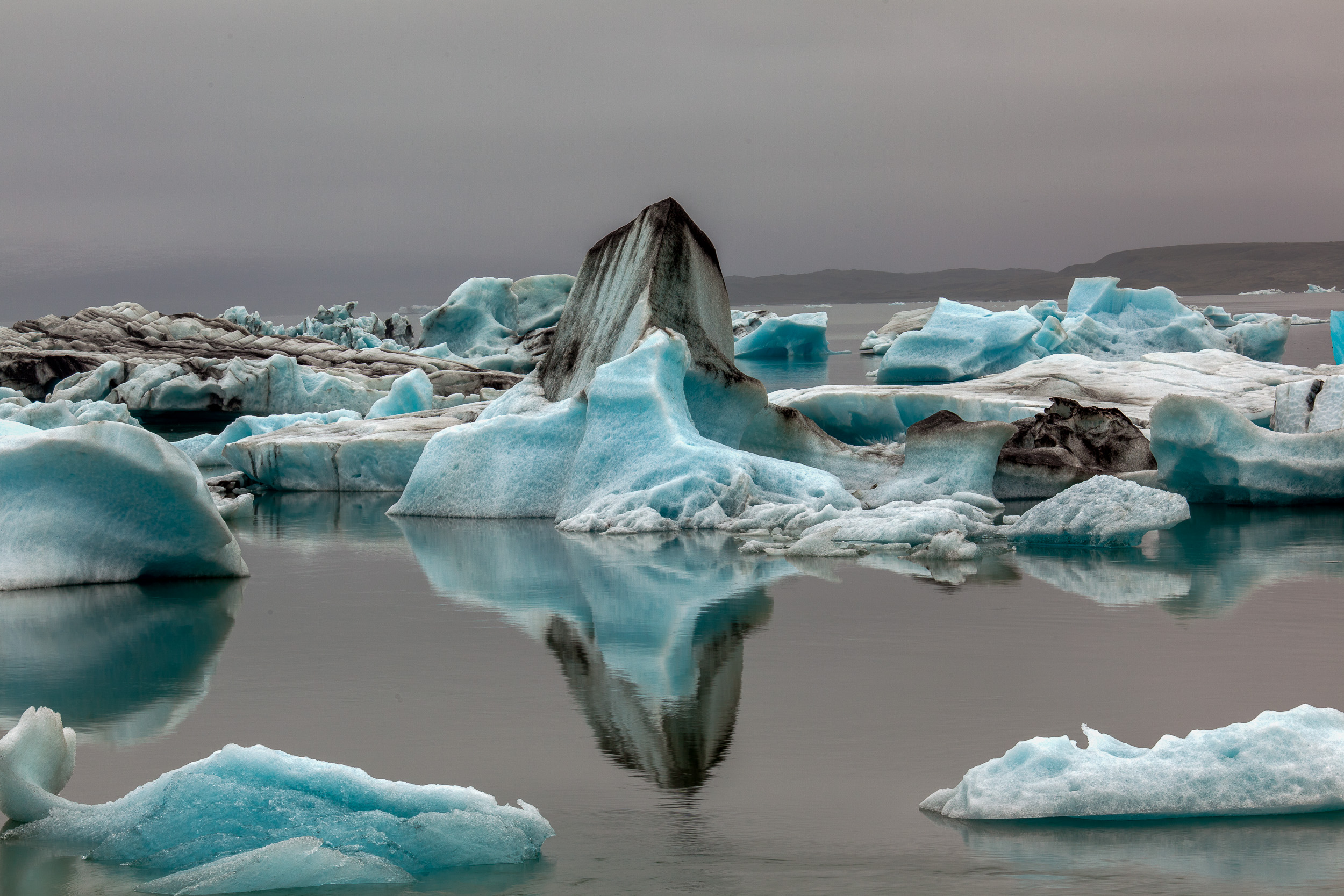 Large icebergs create stunning formations and a beautiful reflection on the Jokulsarlon Glacier Lagoon in Iceland .