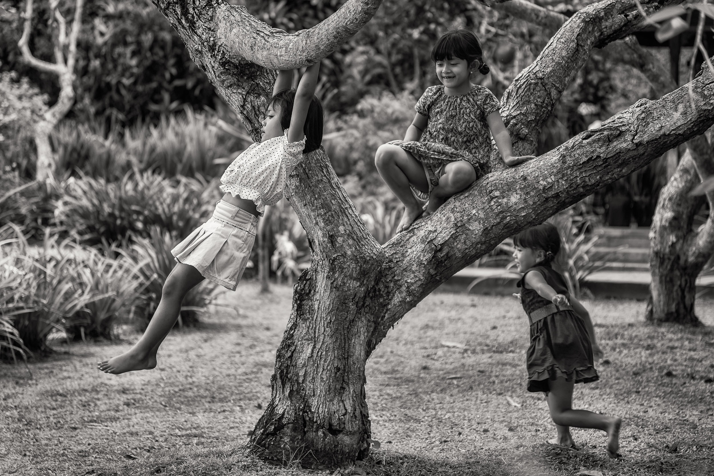 Three young girls at play in the grounds of a Hindu Temple complex in Bali, Indonesia .