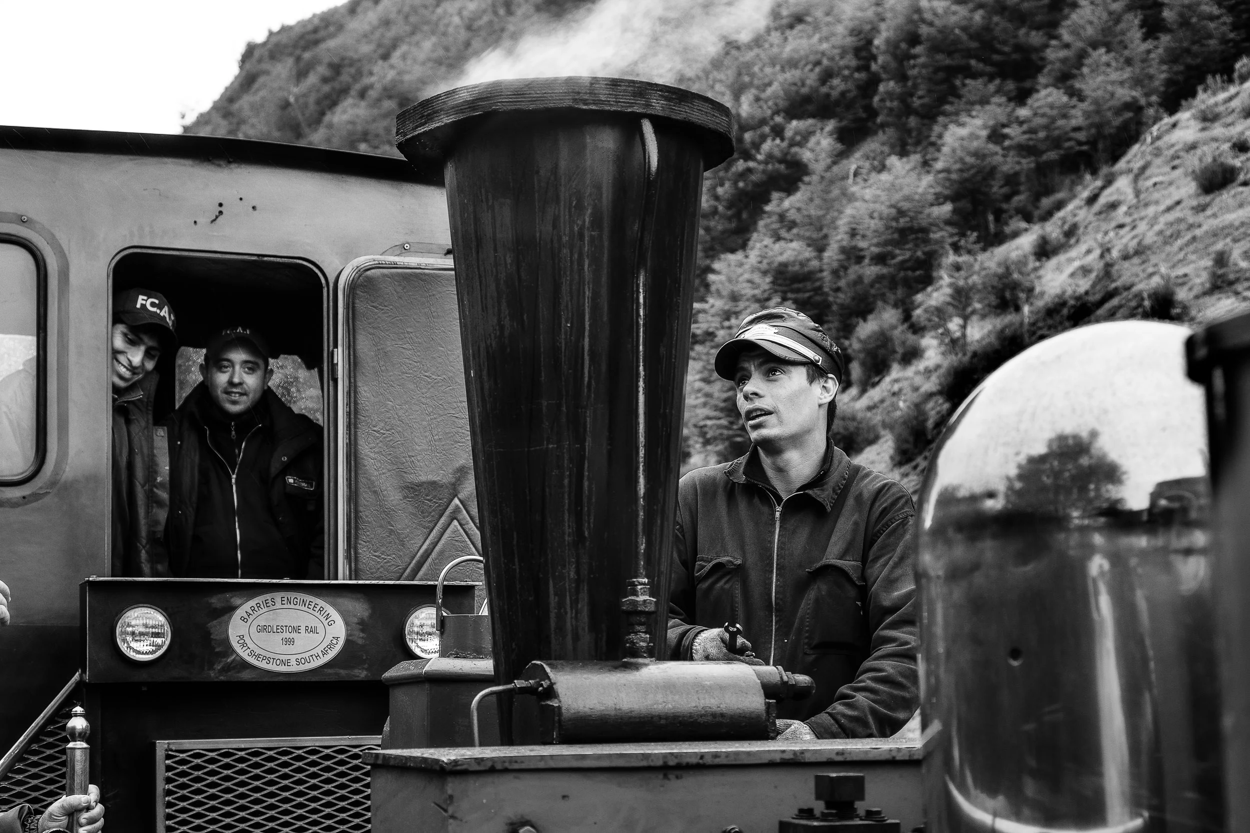 An engineer tinkering with his pride, a lovely steam train in the Tierra del Fuego National Park , Argentina .