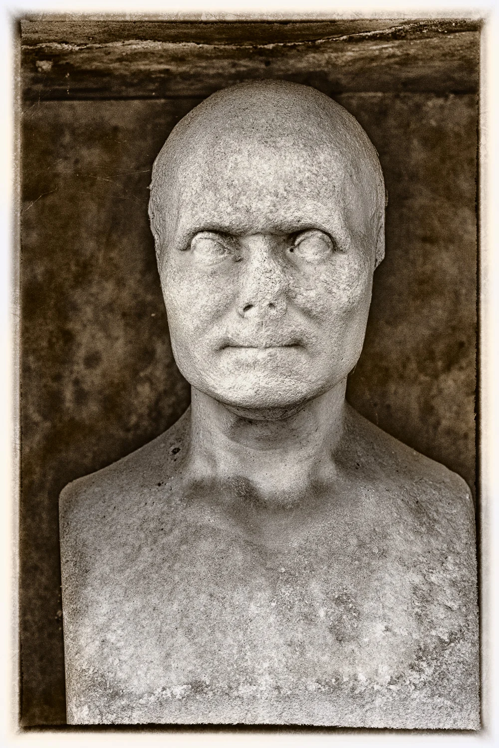 A heavily processed rendering of a bust at Pere Lachaise Cemetery in Paris, France .