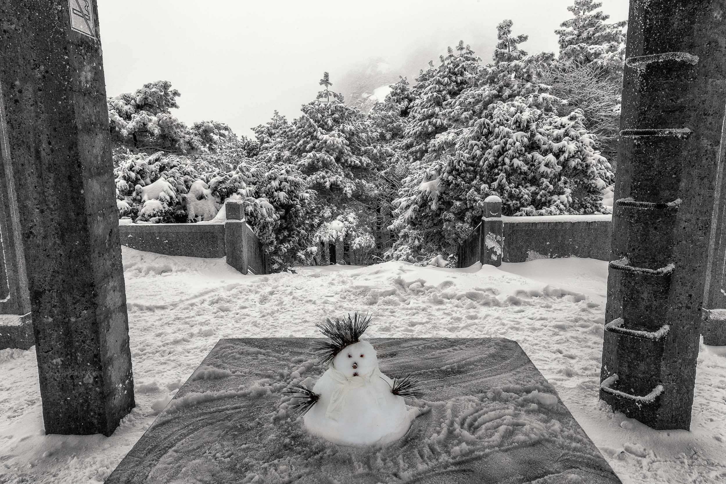 Unique photo of a tiny snowman, under a shelter, Huangshan Mountain, China.