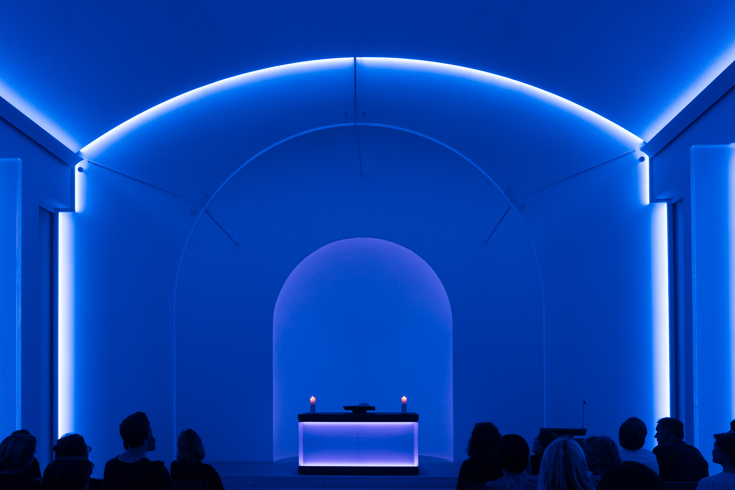The interior of a chapel, illuminated with bluish light , made for a very tranquil and contemplative scene in a cemetery in Berlin, Germany .