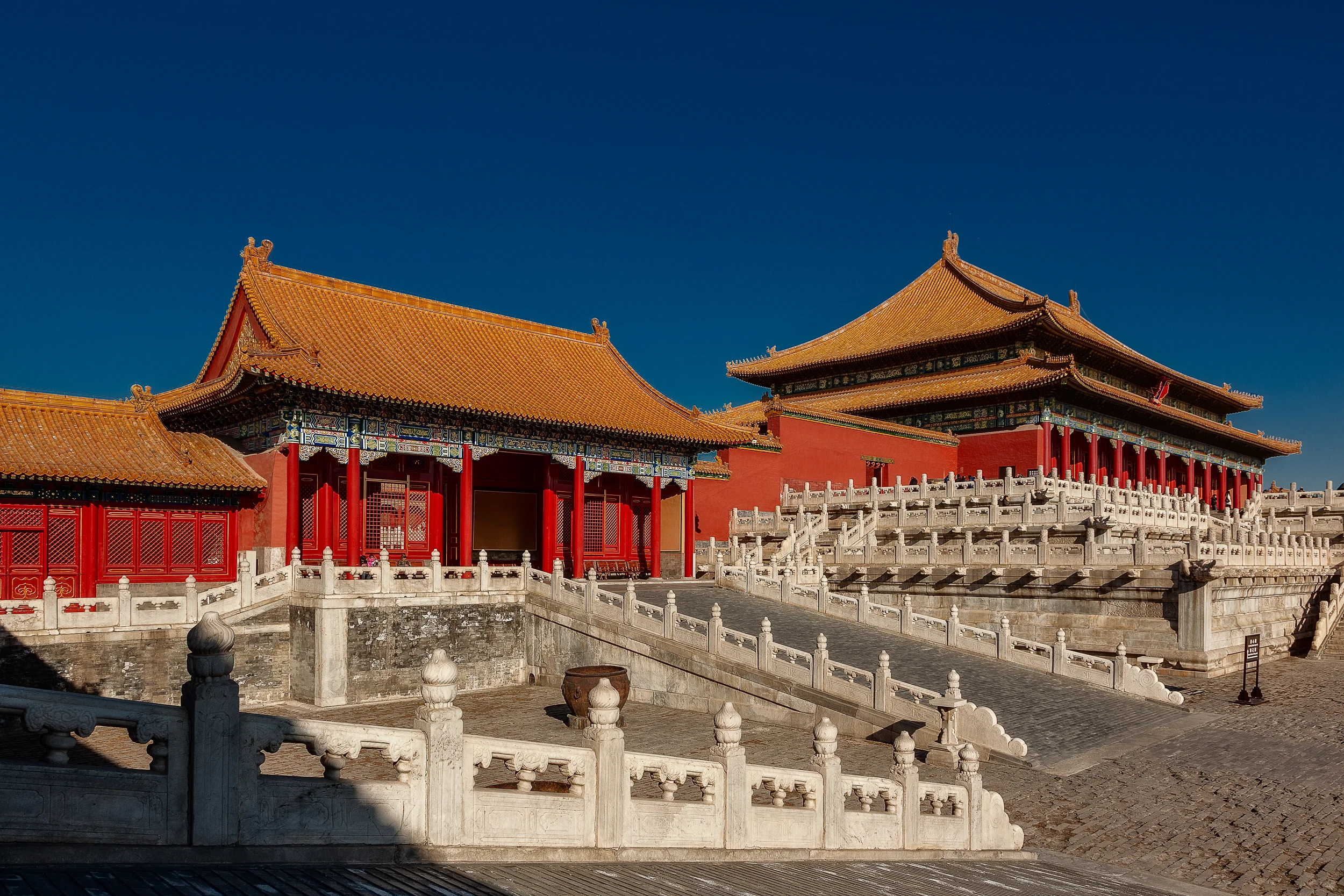 Red walls and orange tiled roofs against a deep blue sky on a spectacular winter's day in the Forbidden City in Beijing, China .