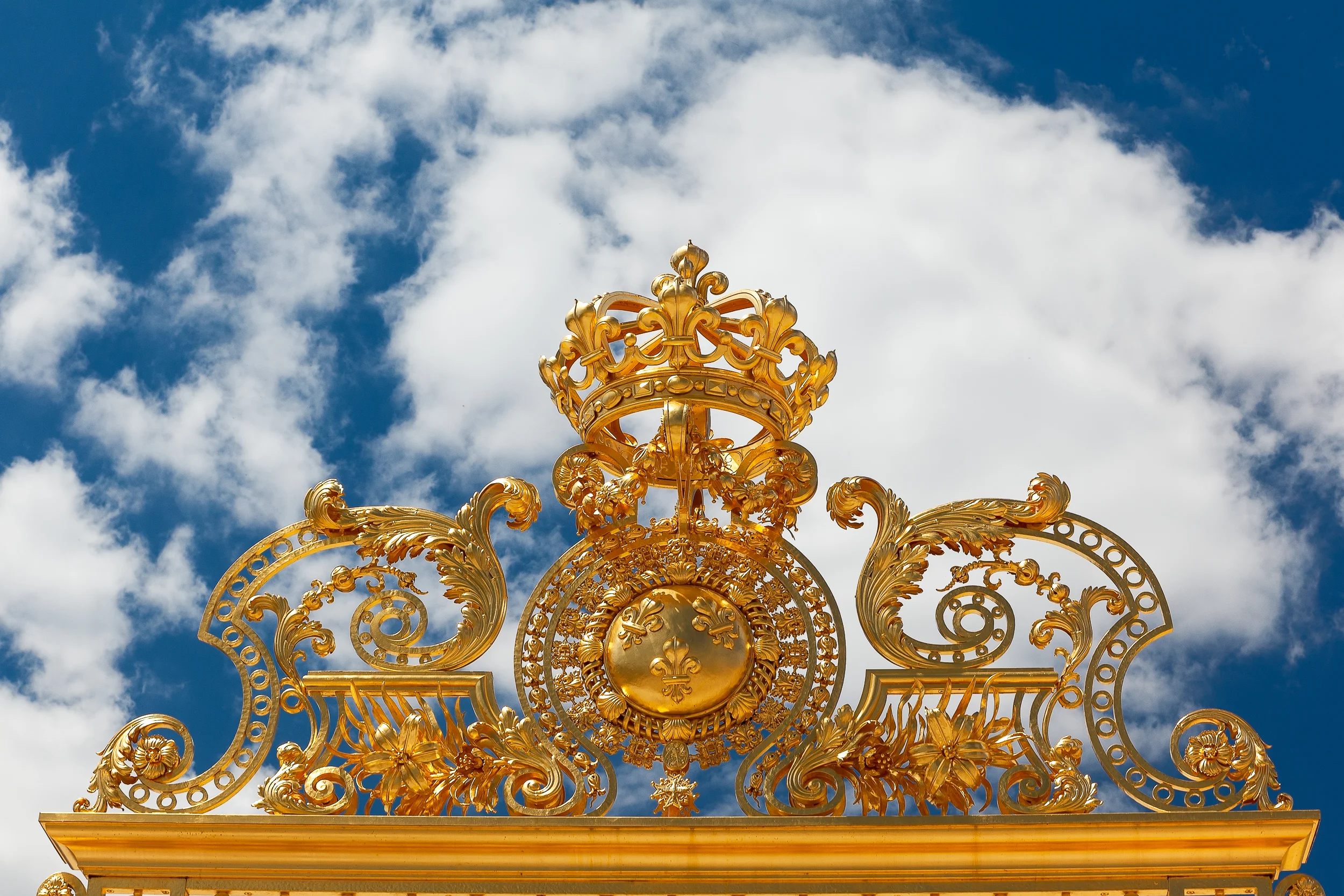 A detail, on the top of the visitor entrance gate, at the glorious Palace of Versailles photographed from a low viewpoint; with a polarizing filter ; and processed with added saturation for extra drama.