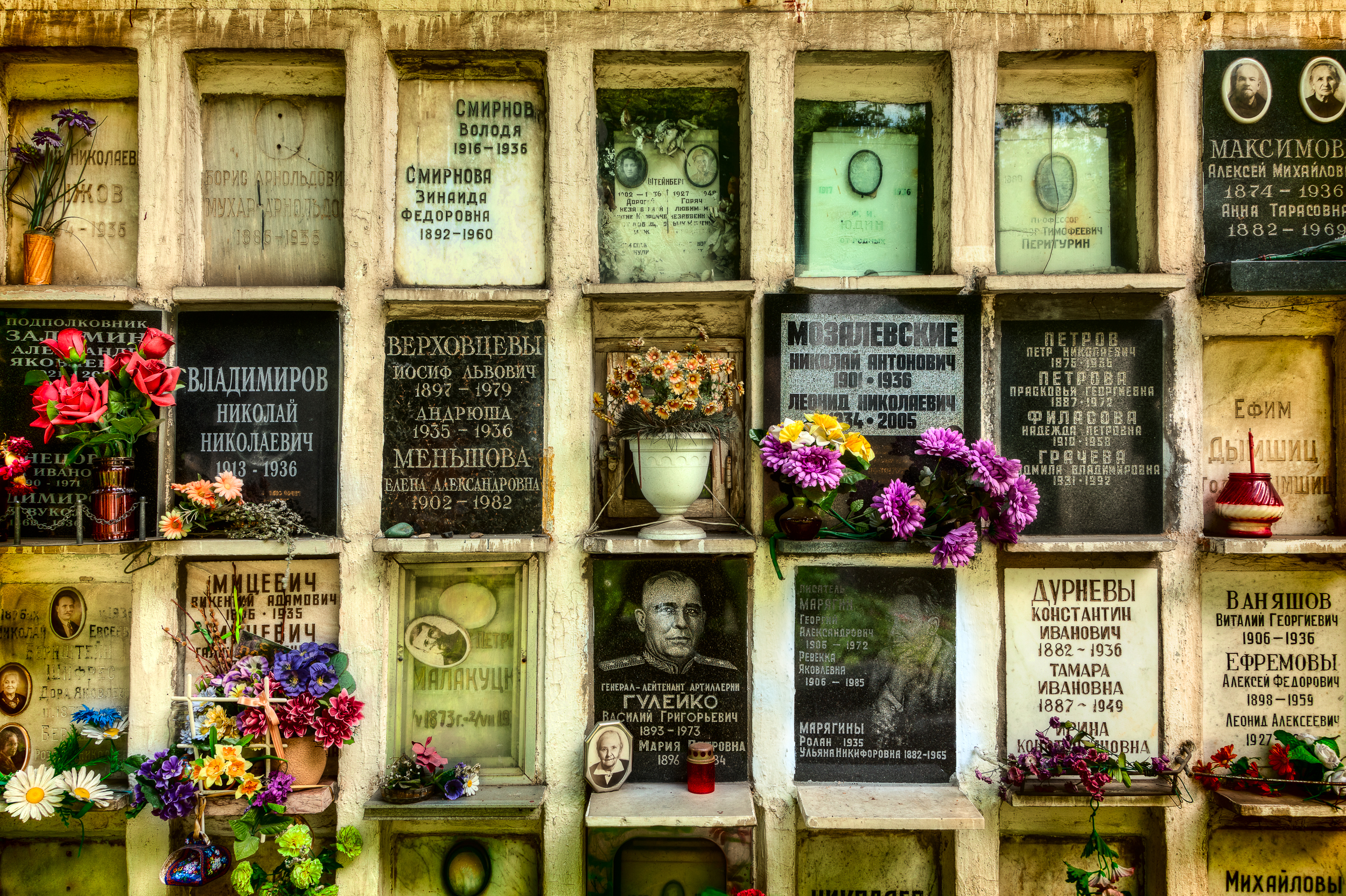 Tiny niche's holding plaques and flowers in the grounds of Novodevichy Cemetery in Moscow, Russia .