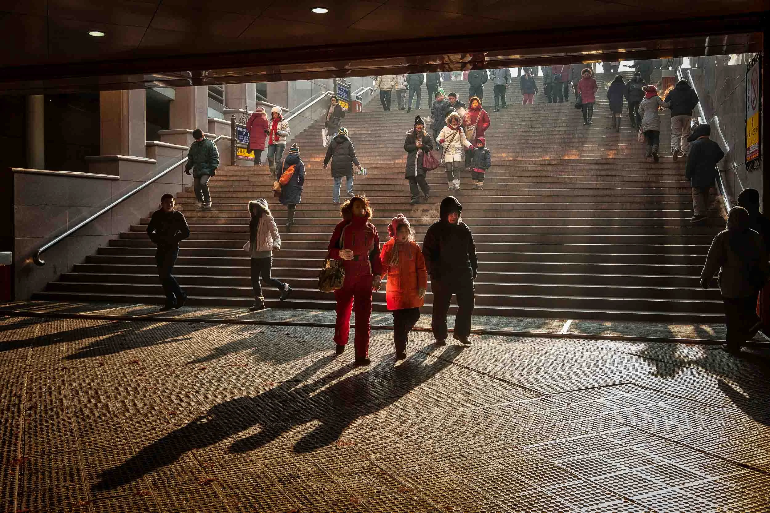 A family make their way into a subway on a cold winter's day in Harbin, China . China holidays provide so many glimpses into the Human Condition.