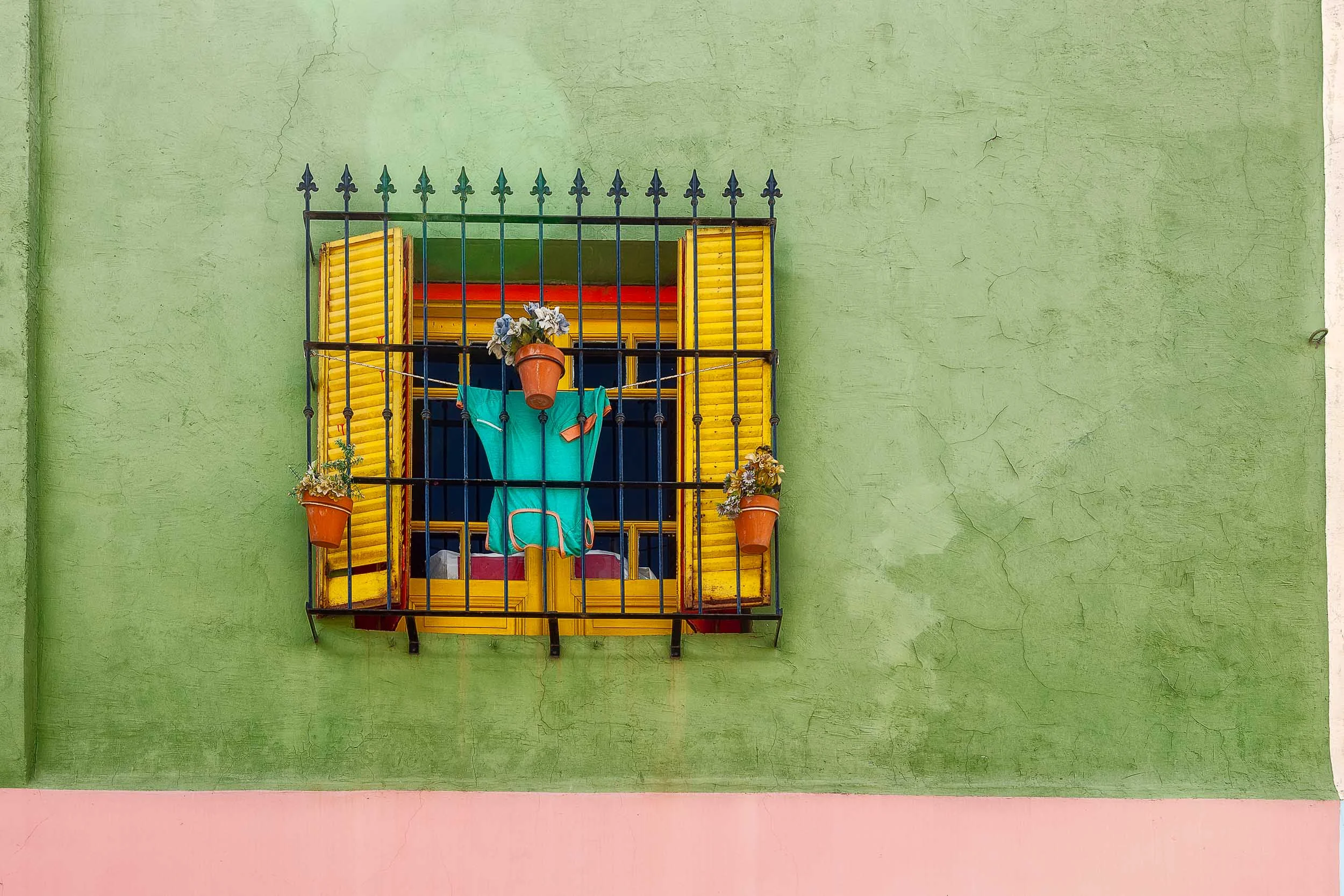 Color, shape and texture underpin this wonderful scene of a decorative window surrounded by a colorful wall in the La Boca precinct of Buenos Aires, Argentina .