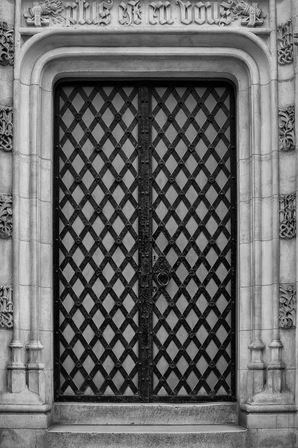 A  metal and wood lattice door  framed by stone speaks to the  rich history  of  Bruges  in  Belgium .