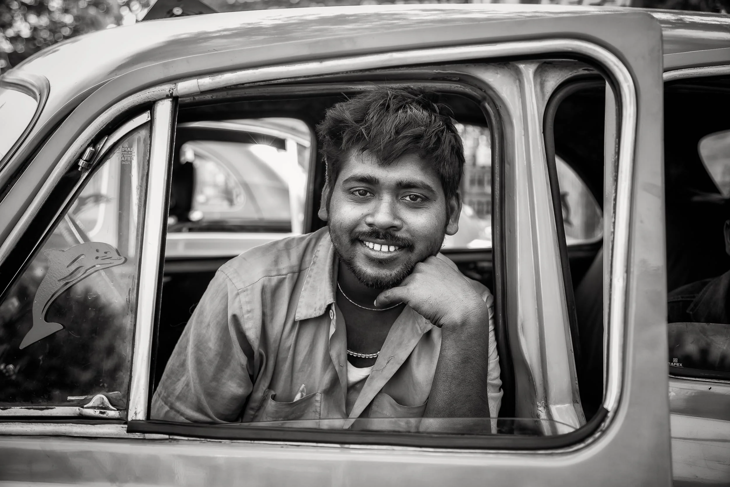 Environmental Portrait of a taxi driver at rest in the back streets of Kolkata, India .