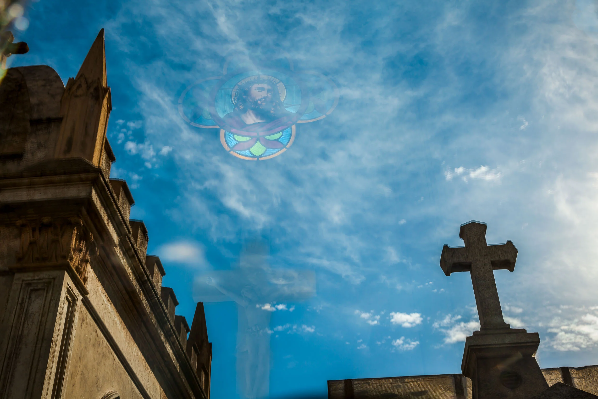 A very surreal photo that, via reflection, displays the face of Jesus in the sky above the magnificent La Recoleta Cemetery in Buenos Aires, Argentina .