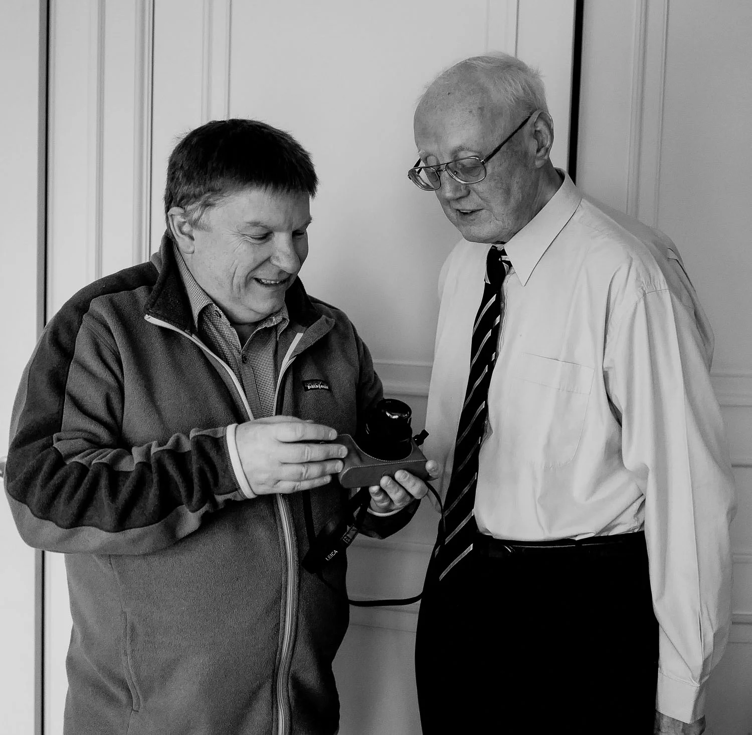 Glenn Guy pointing out a few features on a Leica Q camera to David Aspin . Photo by Judith Chapman .