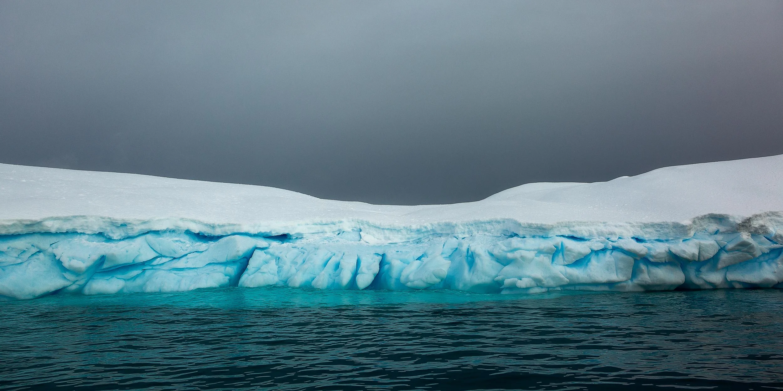 Color and texture prevail in this panoramic view of a large iceberg in Paradise Harbour , Antarctica .