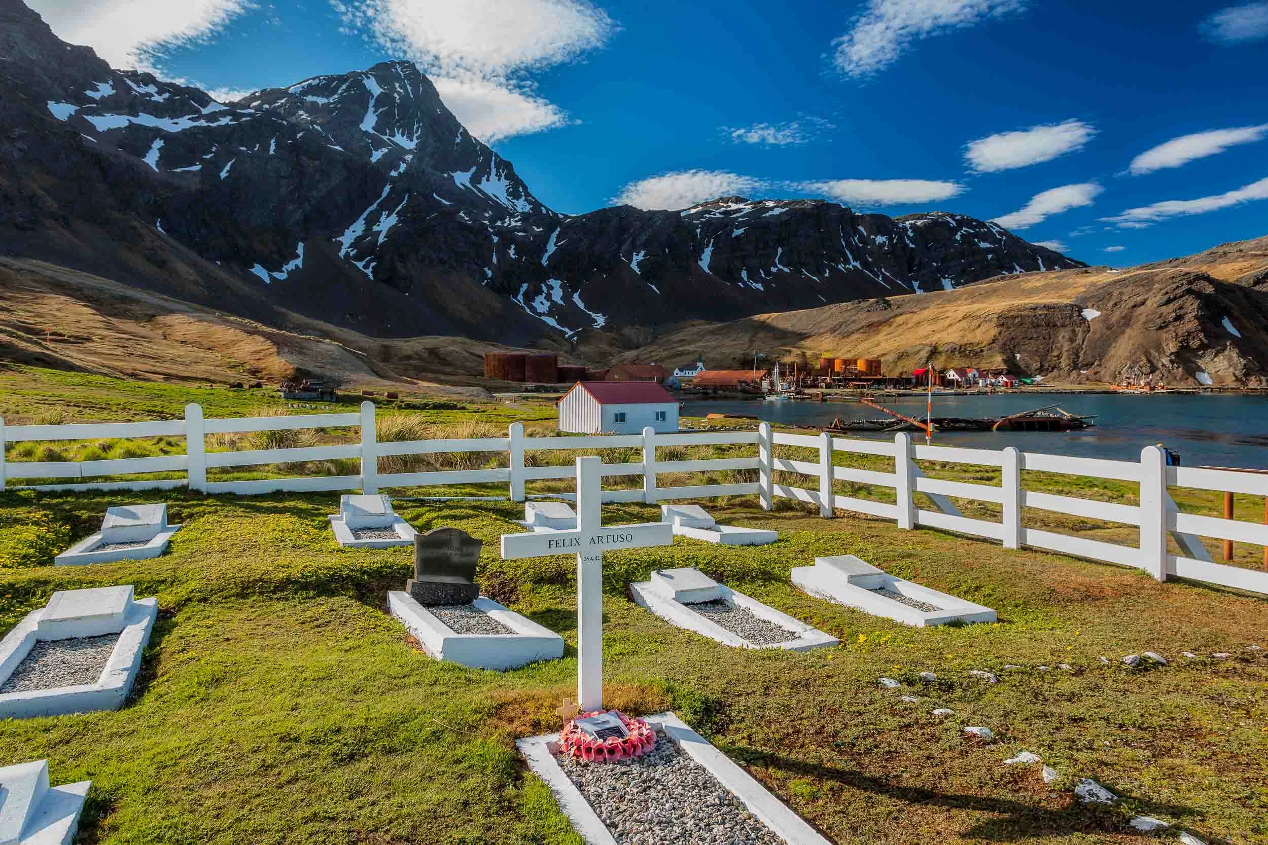 The grave of Felix Artuso set amongst the dramatic landscape surrounding the old whaling station of Grytviken on South Georgia Island .