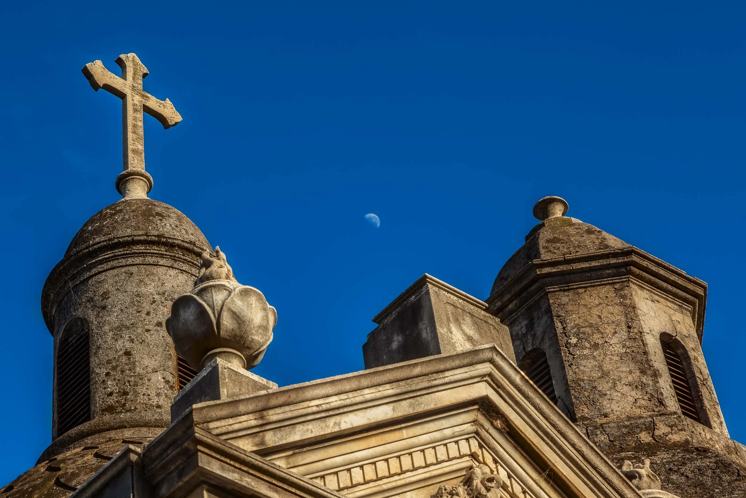 A Christian cross and a moon dominate this colorful image from the La Recoleta Cemetery in Buenos Aires, Argentina .