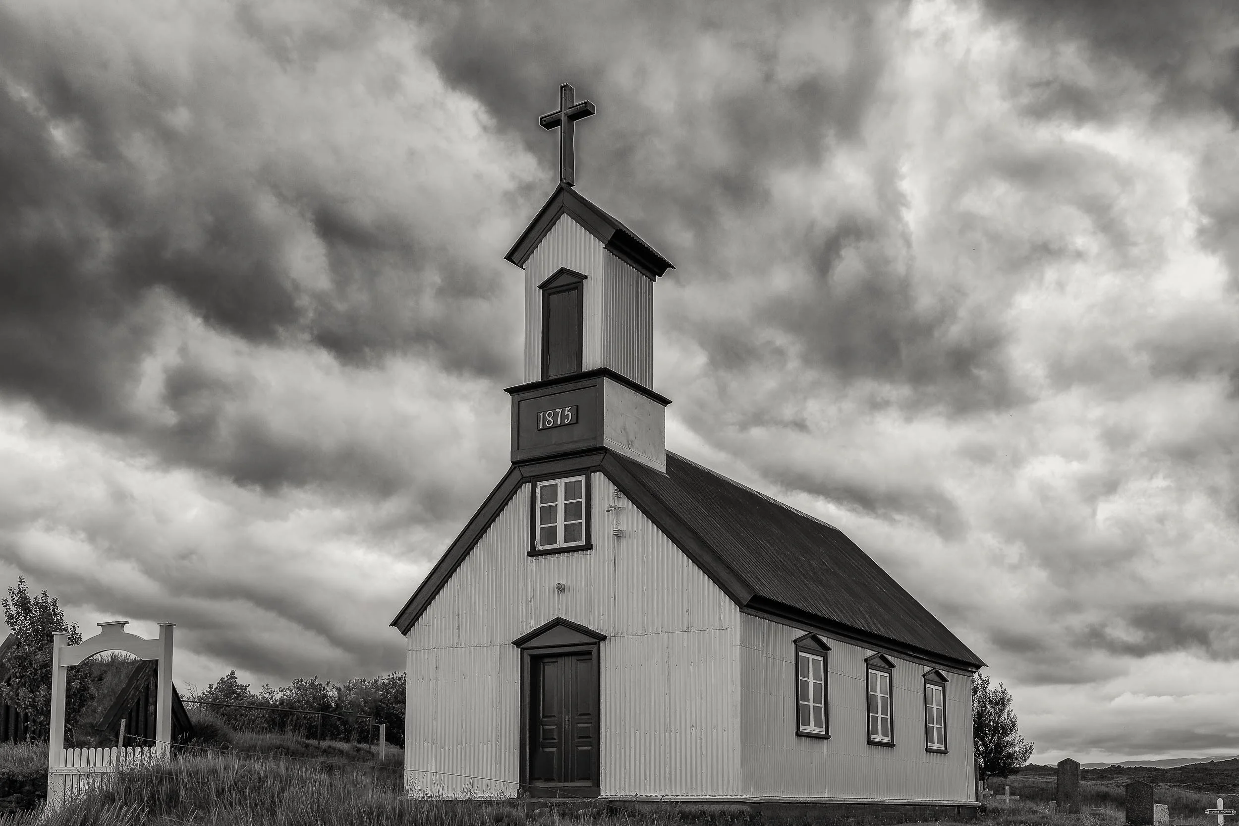 This historic church in southern Iceland is depicted against a dramatic sky foretelling a coming storm.