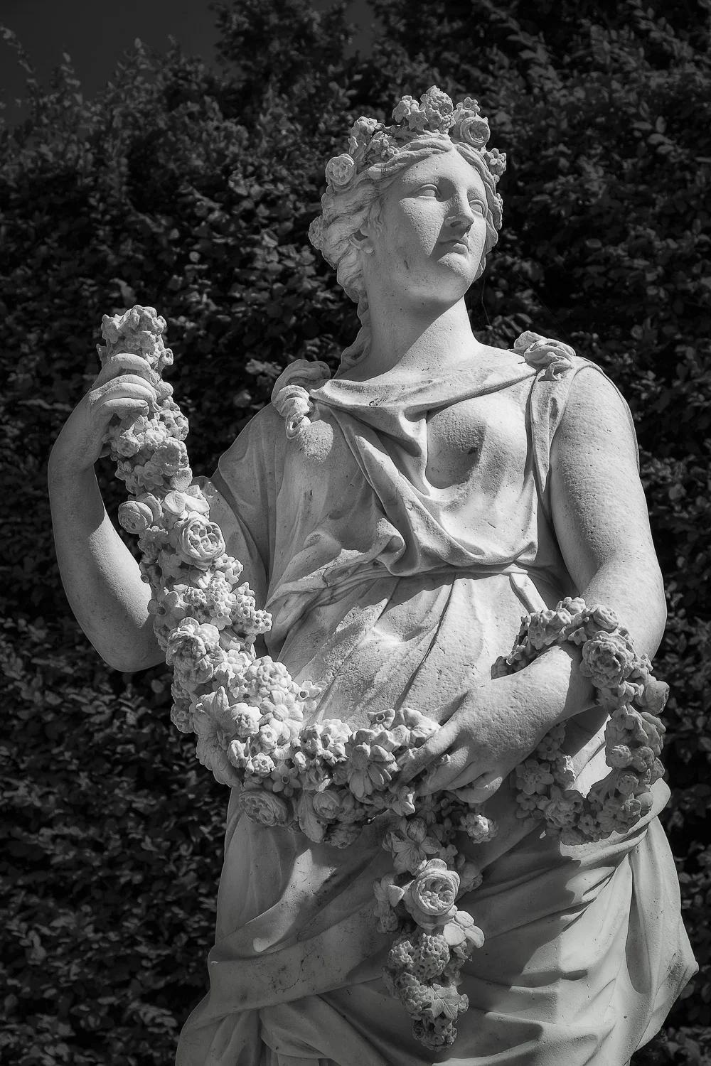 Statue and wreath in the grounds of the Palace of Versailles , France.
