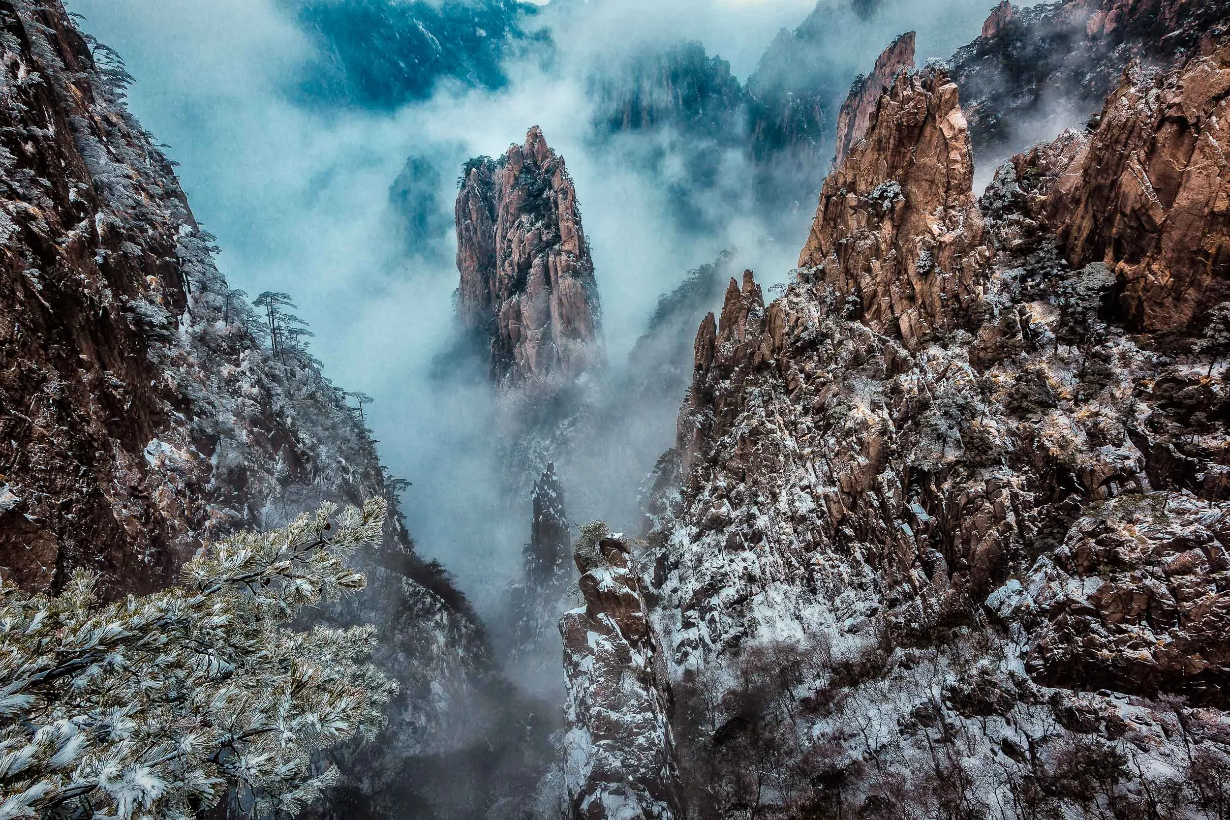 Mist swirling around peaks of stone on Huangshan (i.e., Yellow Mountain), China .