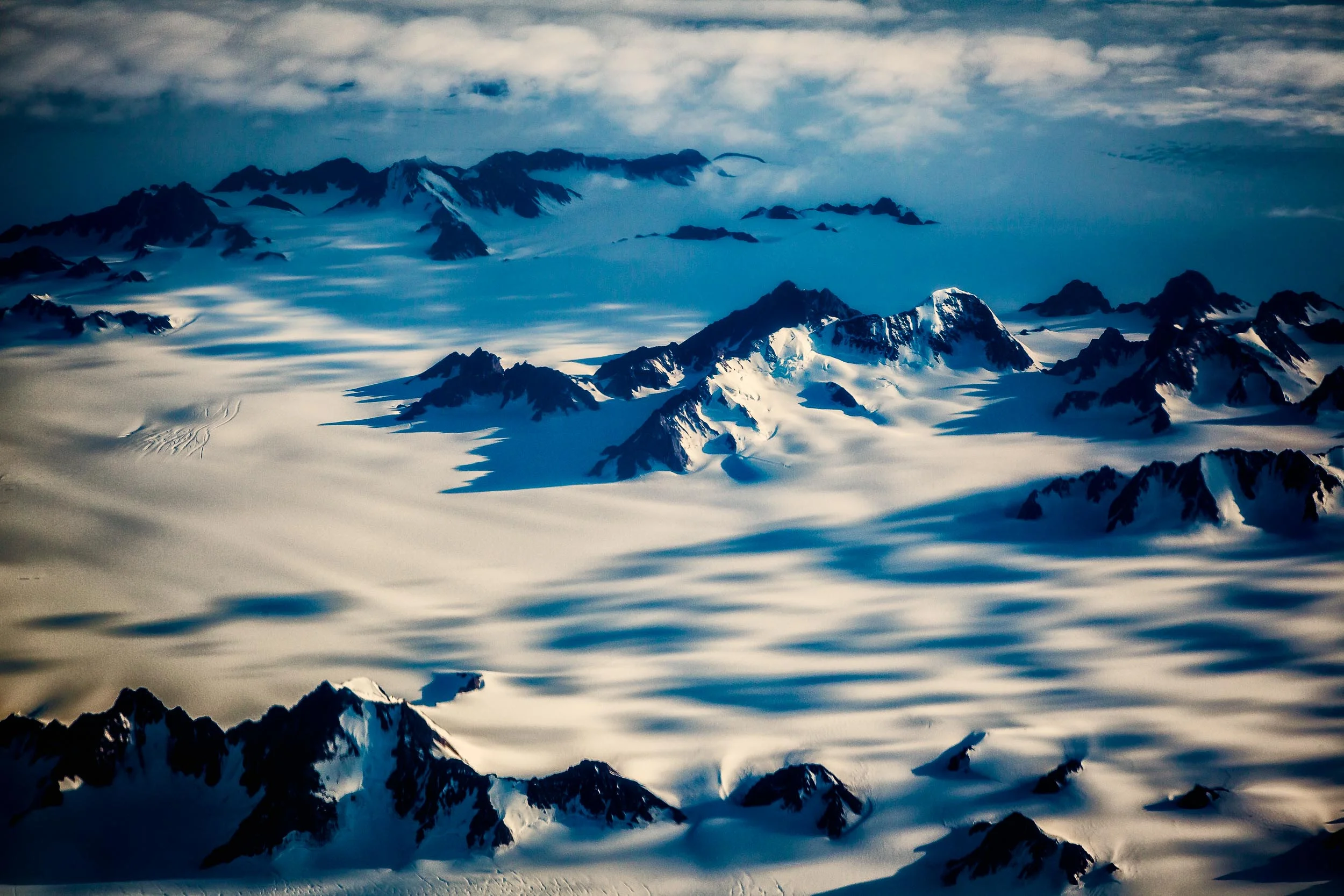 Aerial photography view of a snow-covered, mountainous landscape in Greenland.