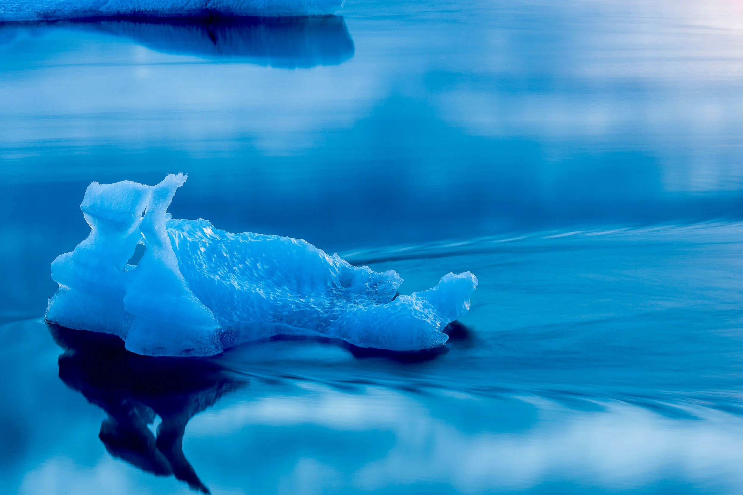 Iceberg, broken off the Breiòamerkurjökull Glacier, travels across Jökúlsárlon Glacier Lagoon, Iceland.