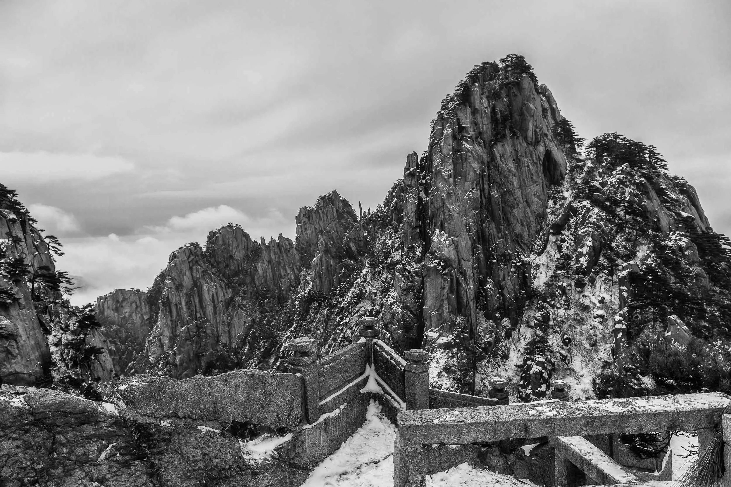 A spectacular and rugged range of peaks photograhed from an outlook on Huangshan (i.e., Yellow Mountain) in China .