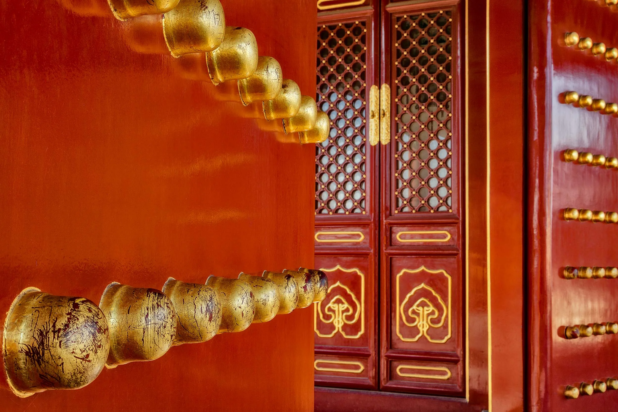 Large brass knobs lead the eye to a fabulously decorated door at the Temple Of Heaven in Beijing, China .
