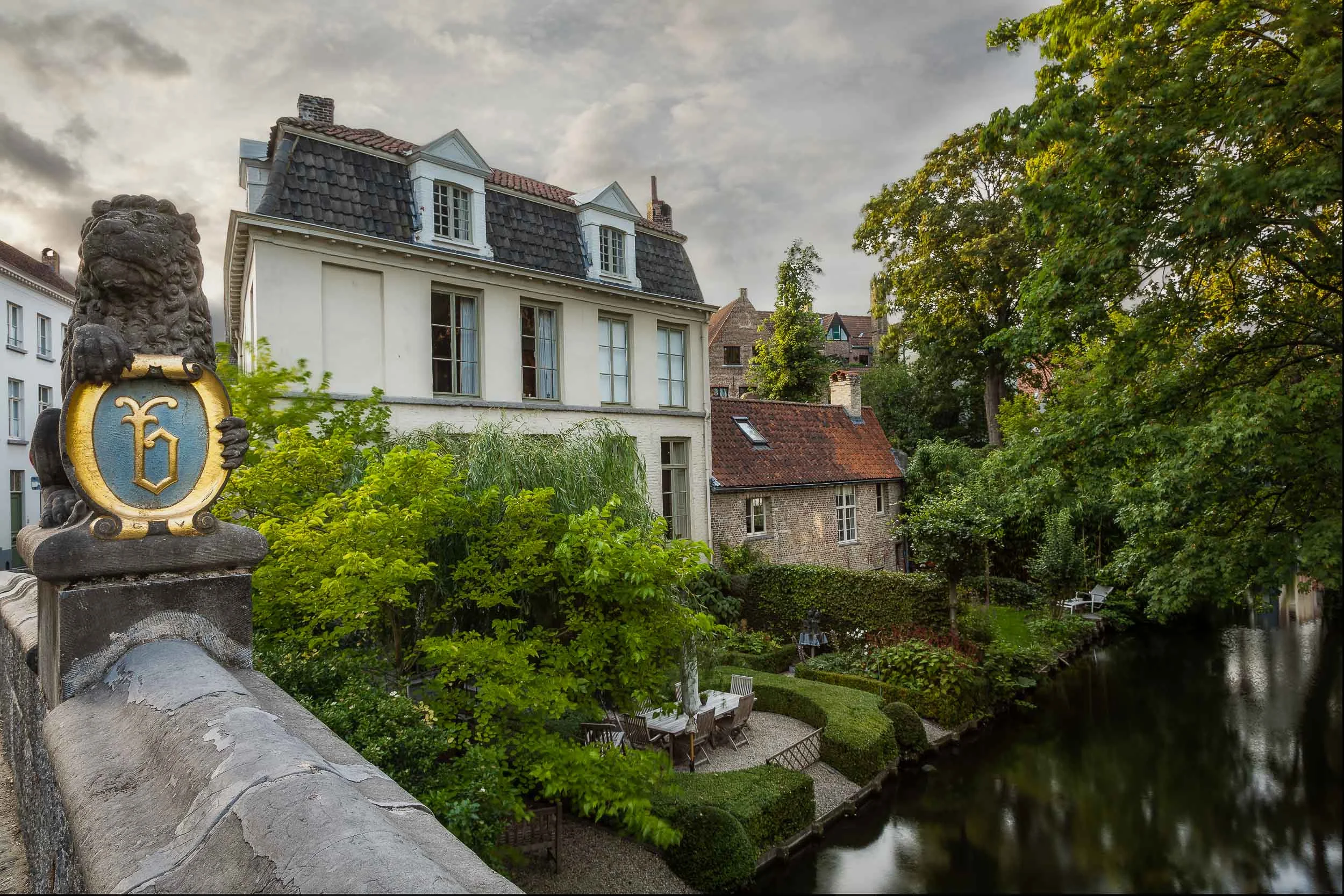 Houses by the canal in the beautiful city of Bruges, Belgium .