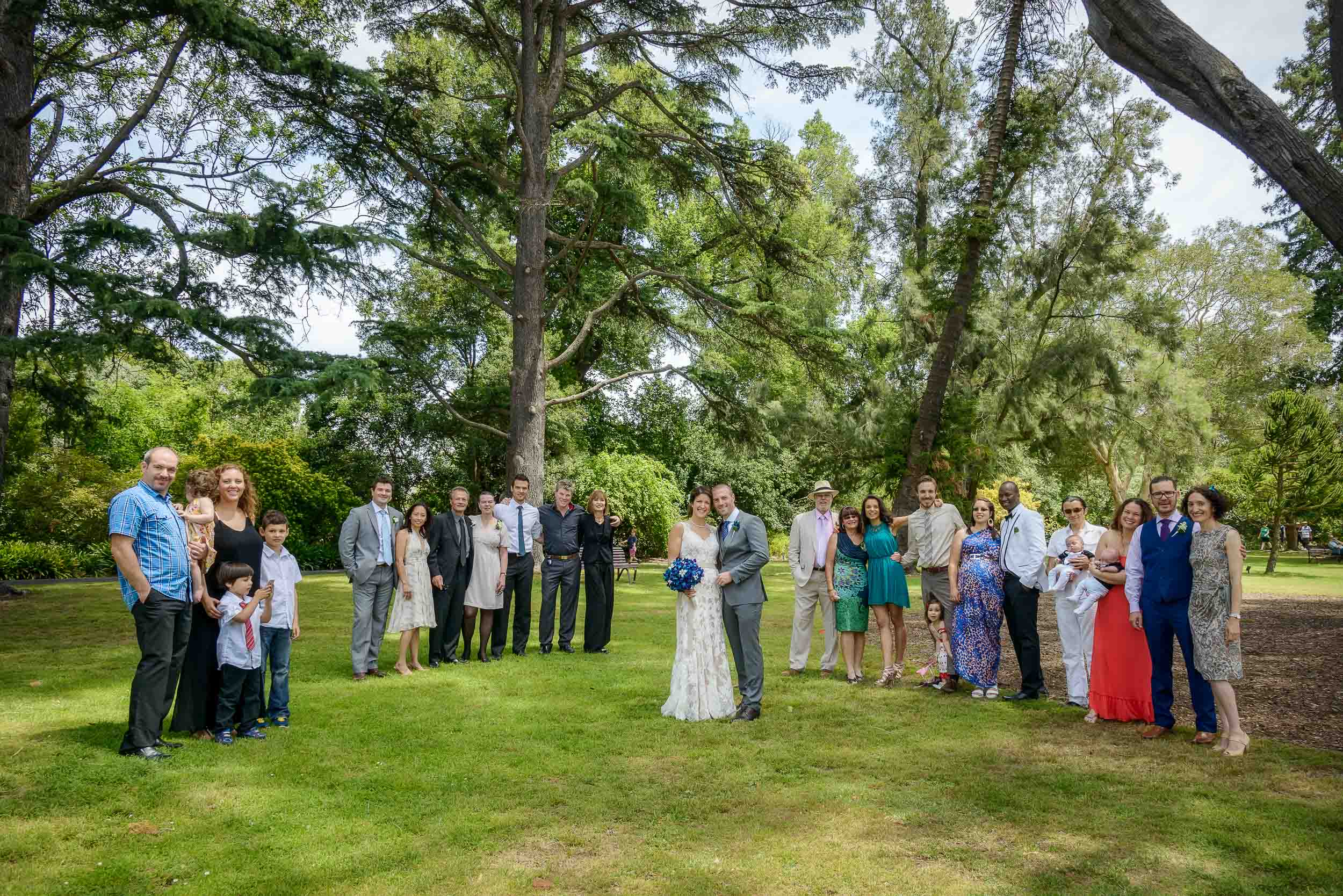 Group photo of bride and groom's extended families at an outdoor location.