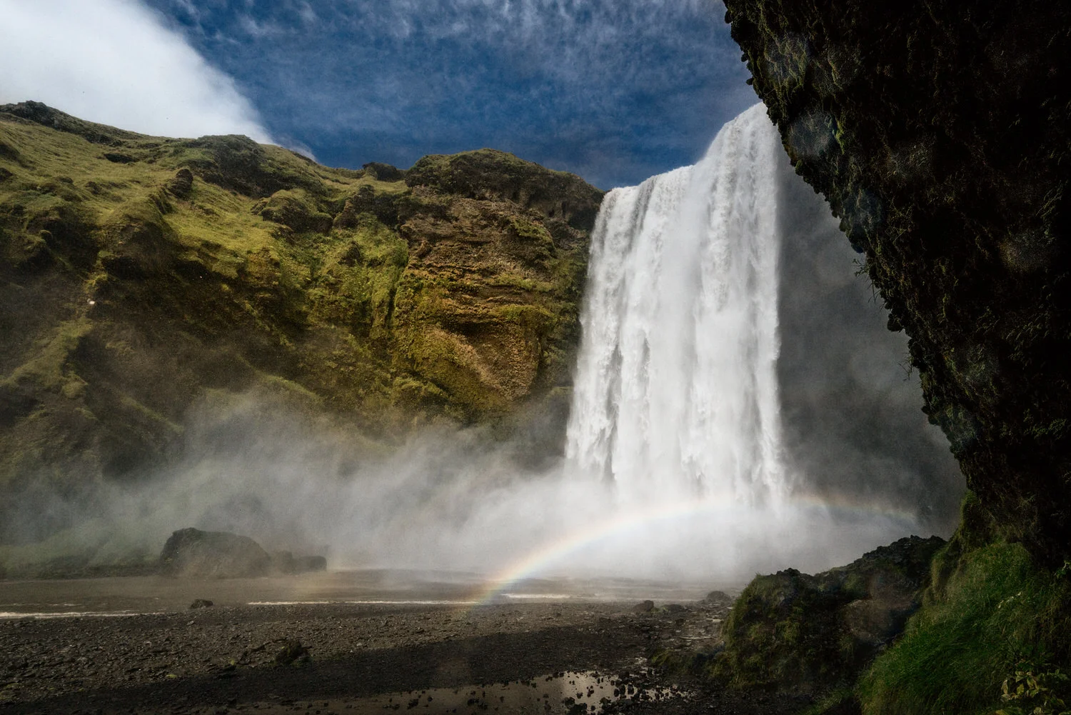 A rainbow appears at the bottom of the magnificient Skógafoss waterfall in southern Iceland .