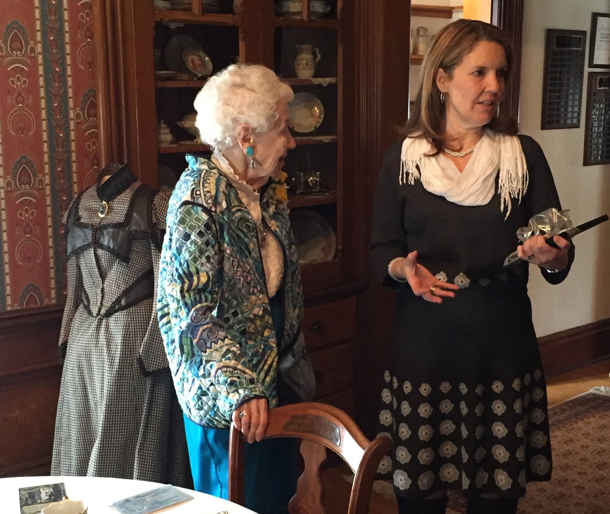 Margaret Brown (l.) and Avery Guild Costume Chair Kimberly Miller (r.). Behind Margaret is a dress she donated to the Avery House as part of the collection. The dress illustrates the 1890s-1900s "health corset." At the turn of the century, there was mainstream public concern about the health hazards of tight corsets, and the "health corset" was born as manufacturers rushed to assure consumers that their corsets were made according to the latest scientific principles and would not harm internal organs or hinder breathing.