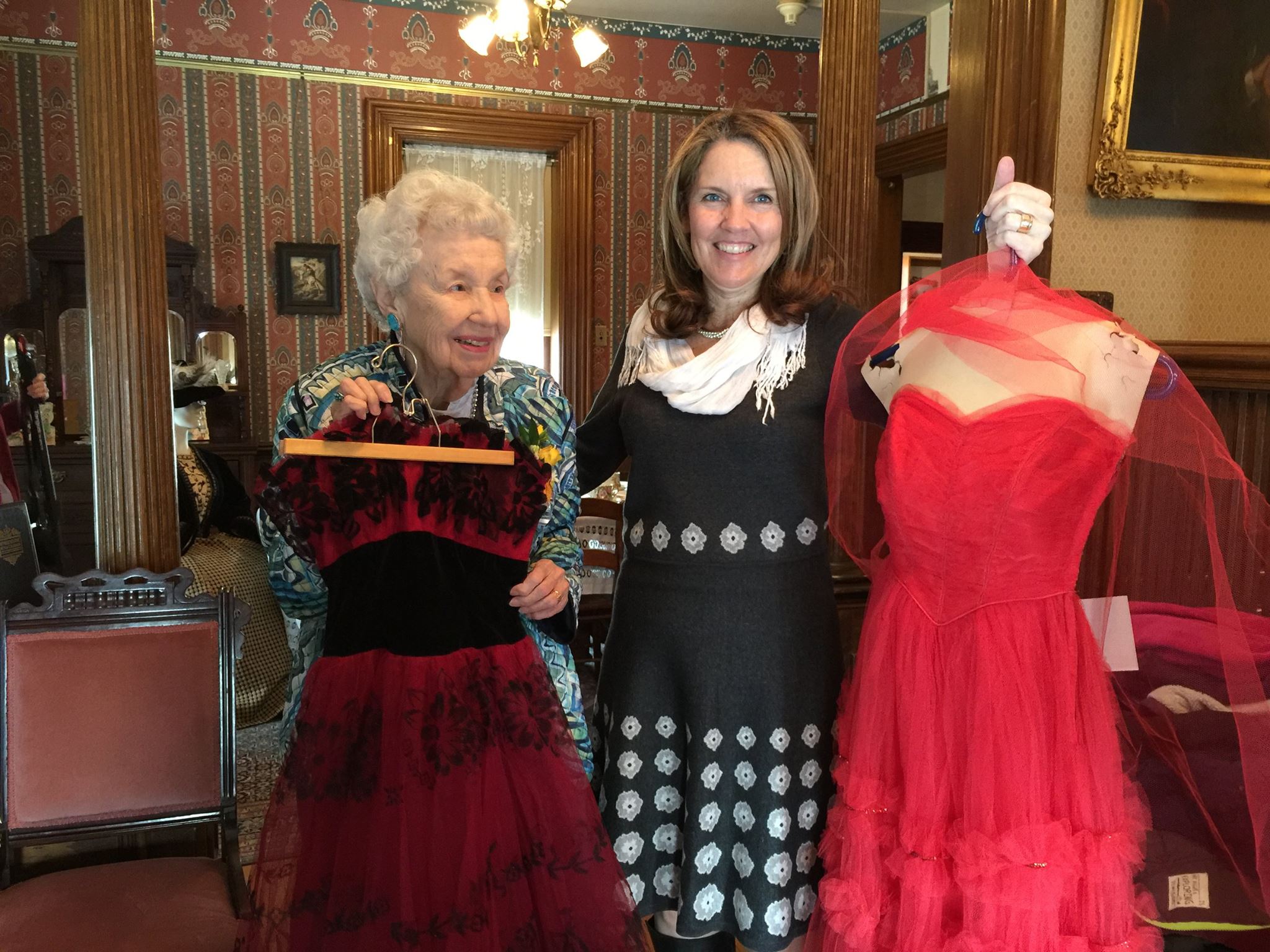  Margaret Brown (l.) and Avery Guild Costume Chair Kimberly Miller (r.) hold dresses that are part of the Margaret Brown Collection but not yet on public display. The Margaret Brown Collection is on display at the Avery House Feb-July 2016, and duri