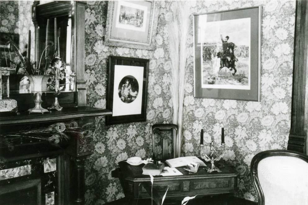 Circa 1980 - Black and white photograph of the interior of the Avery House located at 328 West Mountain Avenue; Fort Collins, Colorado. This photo shows the furnishings and decorations of a corner of a room.