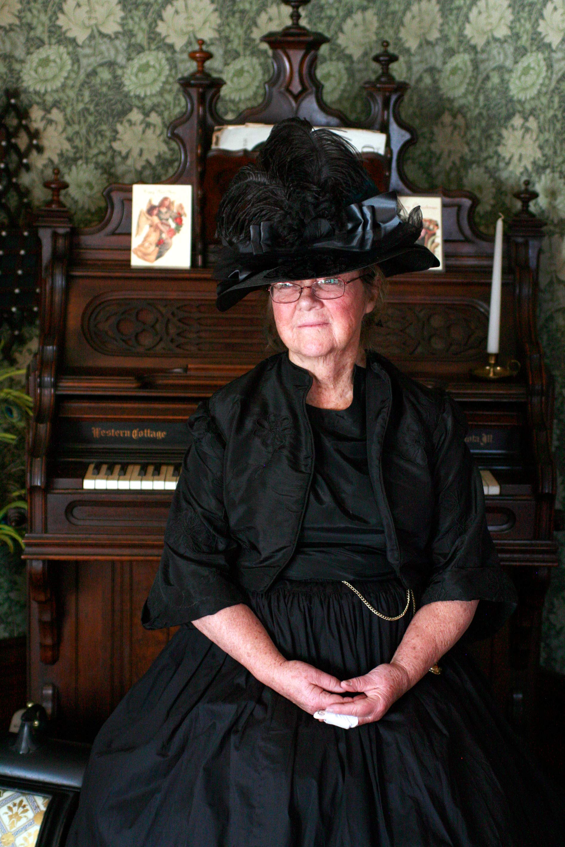 A volunteer docent sits at the organ in the Avery House