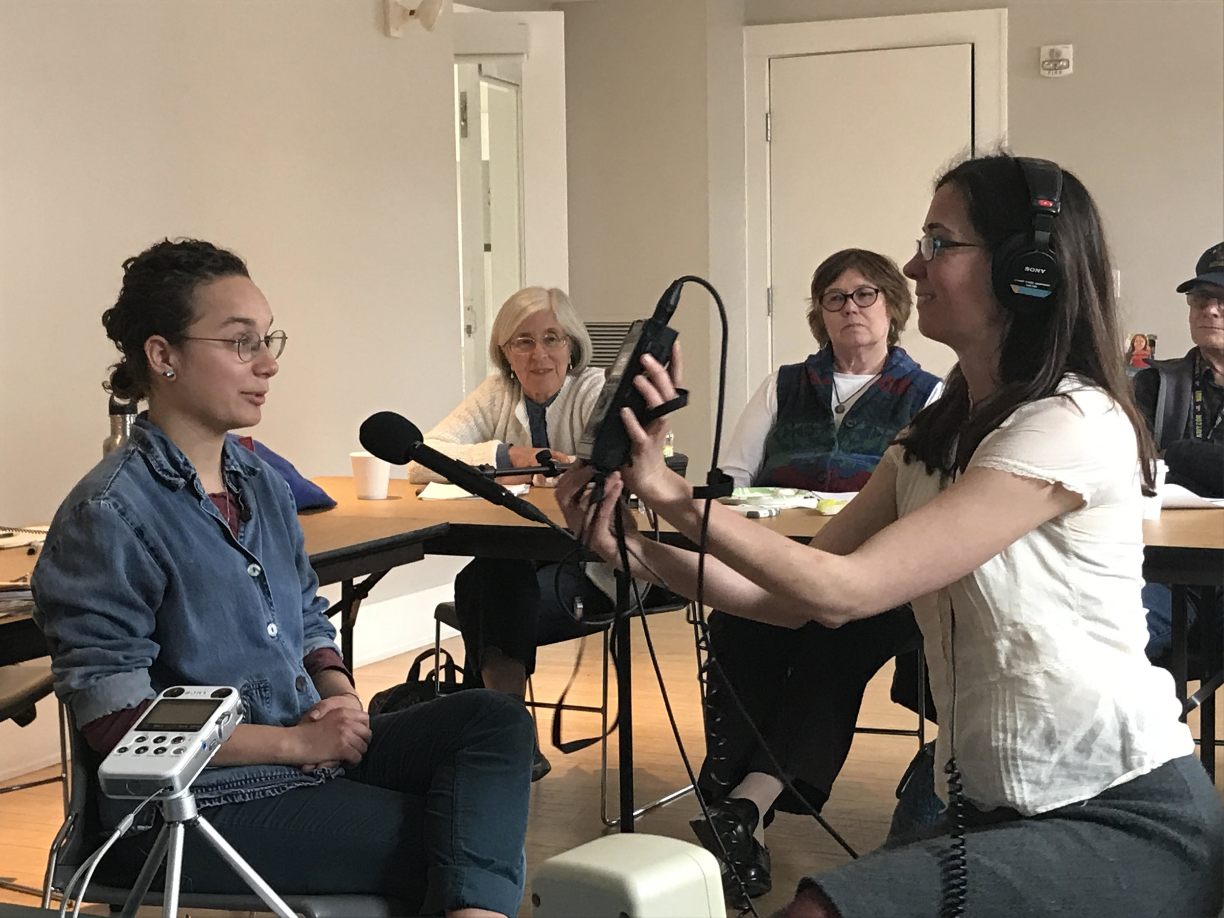 Meghan (right) shows the class how to check their audio levels with Eloise Schultz (left) as the test interviewee. Photo by Tim Garrity. 