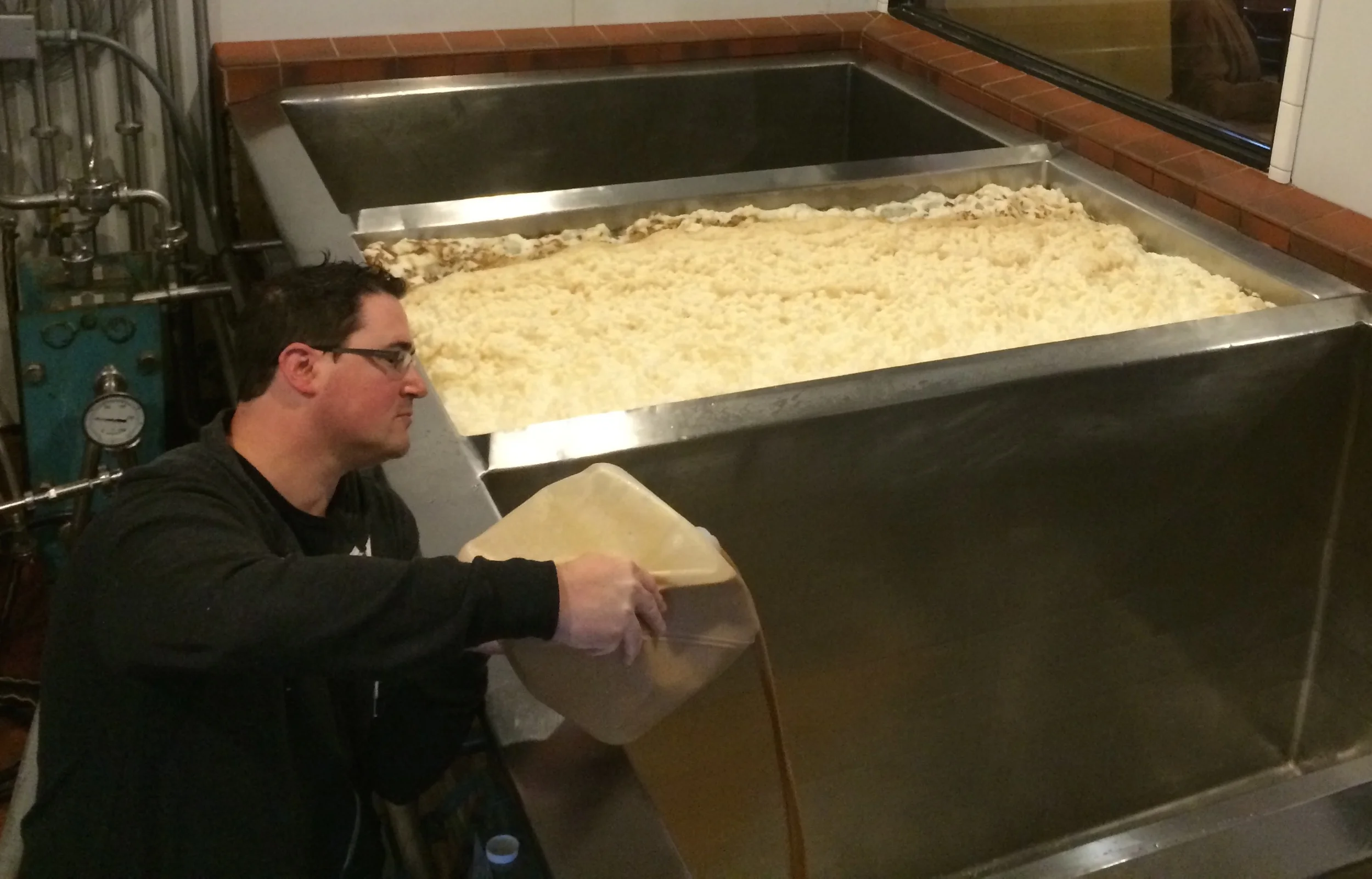 Peter Hoey of BSG CraftBrewing pitches the Saison yeast for the Fünke Canadien into an open-fermentation tank at Sudwerk Brewery in Davis, Calif., in February.