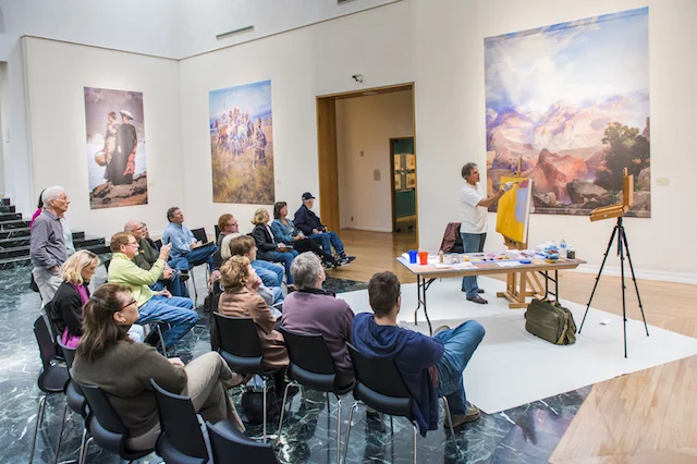 Painting demonstration surrounded by large reproductions of the Masters, photo courtesy of Gilcrease Museum 