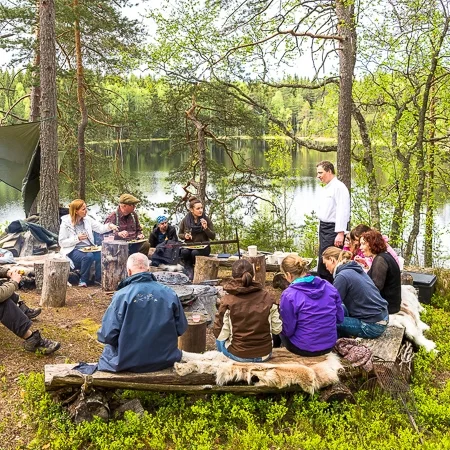Group of people having a meal in nature, Finnish nature, Råmossa Lodge