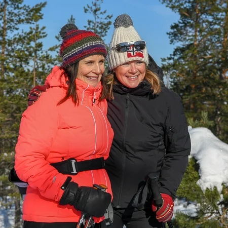 Two women hiking outdoor in Finnish nature, winter time, Råmossa Lodge