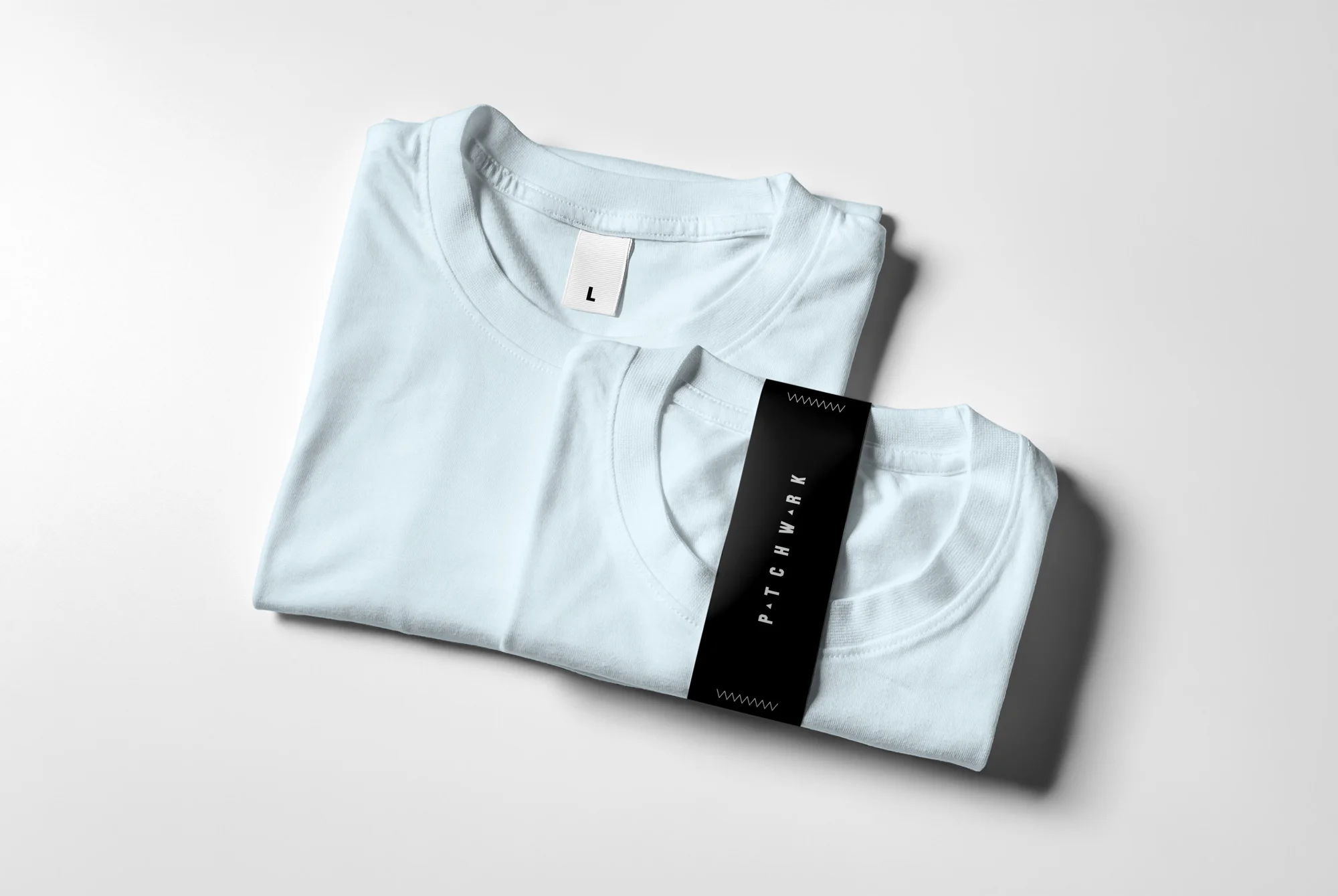 09_T-Shirt-Mock-up-2_front-folded-&-paper-band_perspective-view.jpg