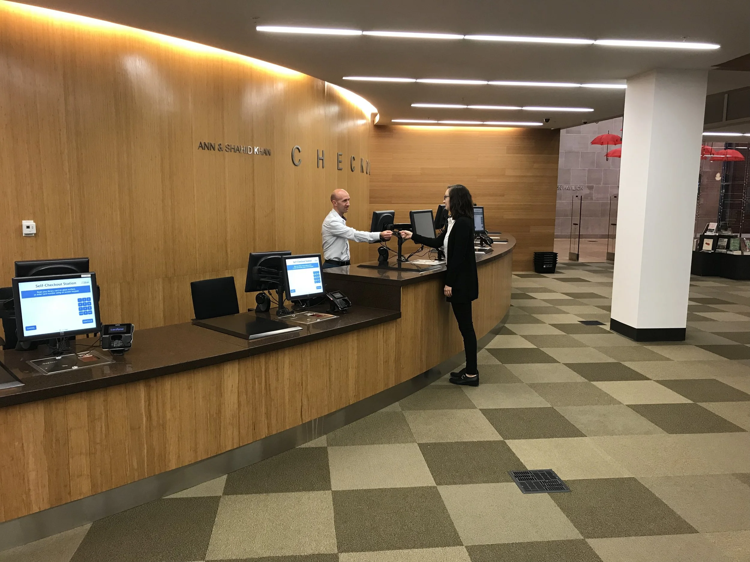 Ruairi McEnroe assists a customer at the Champaign Public Library.