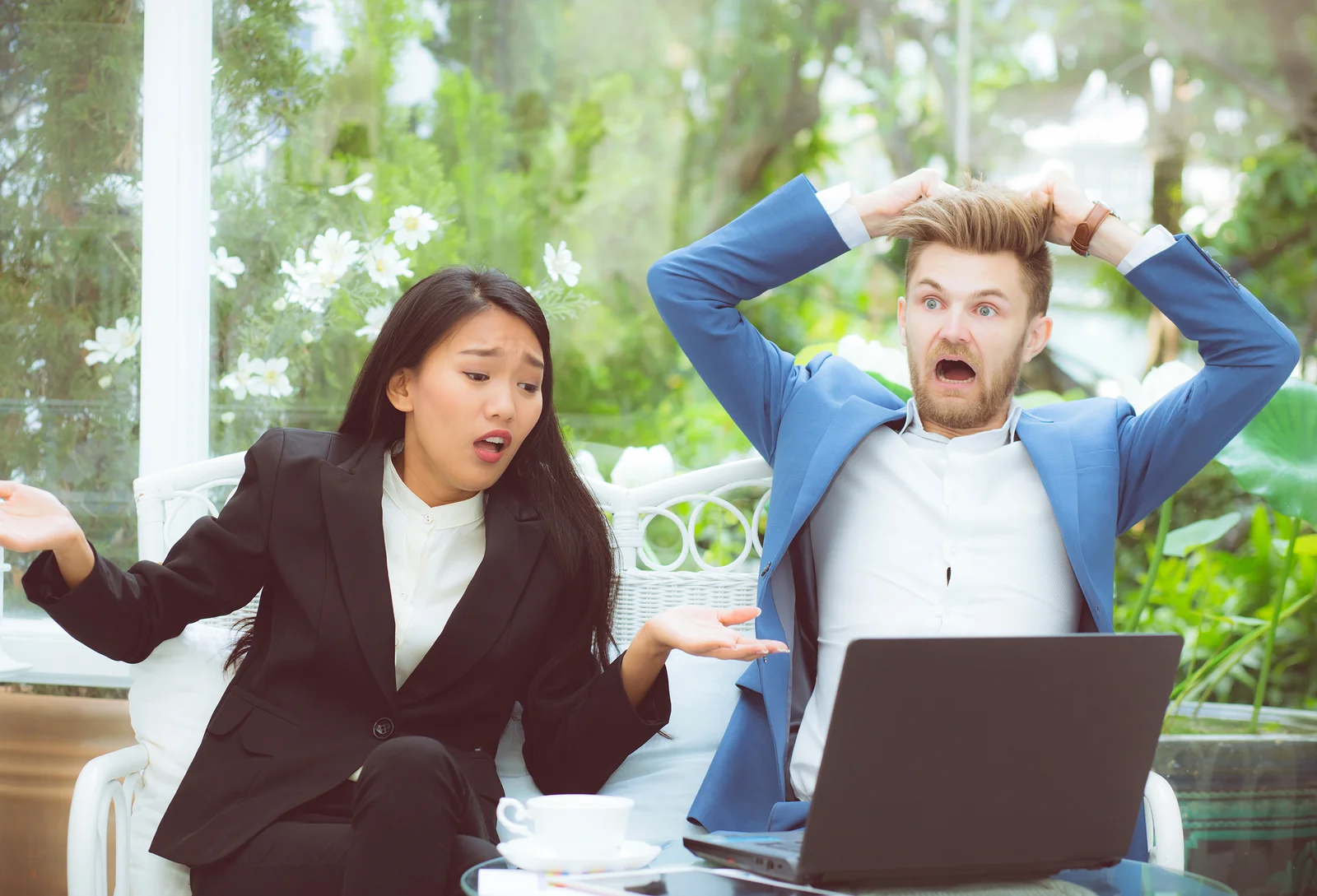 Two surprised and unhappy customers reacting to something they see on a computer.