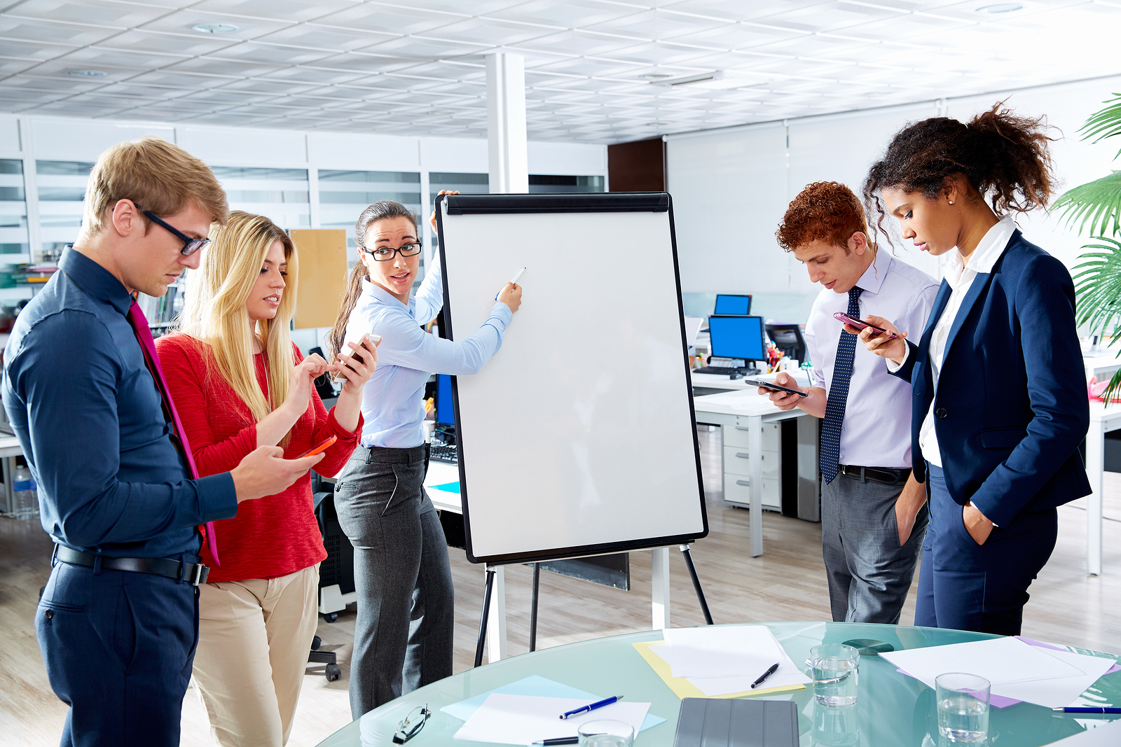 Boss presenting to a group of distracted employees.