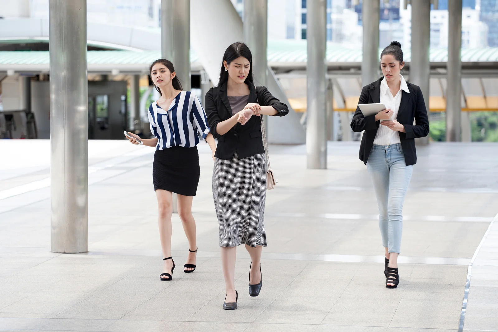Group of businesswomen running late.